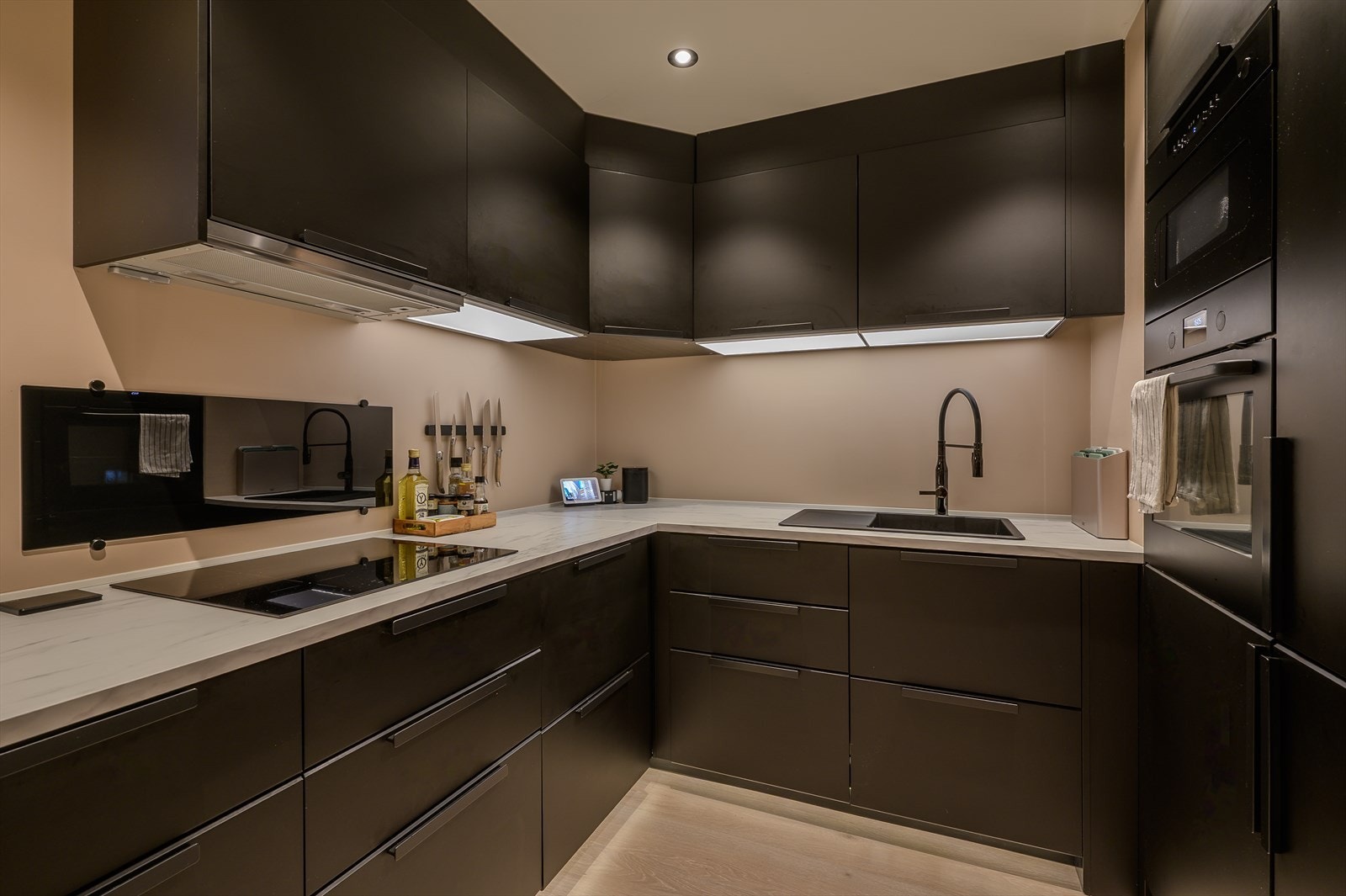 Kjøkkenet på 10,5m² byr på rikelig med både skap- og benkeplass i lekre, sorte detaljer. Galleribilde