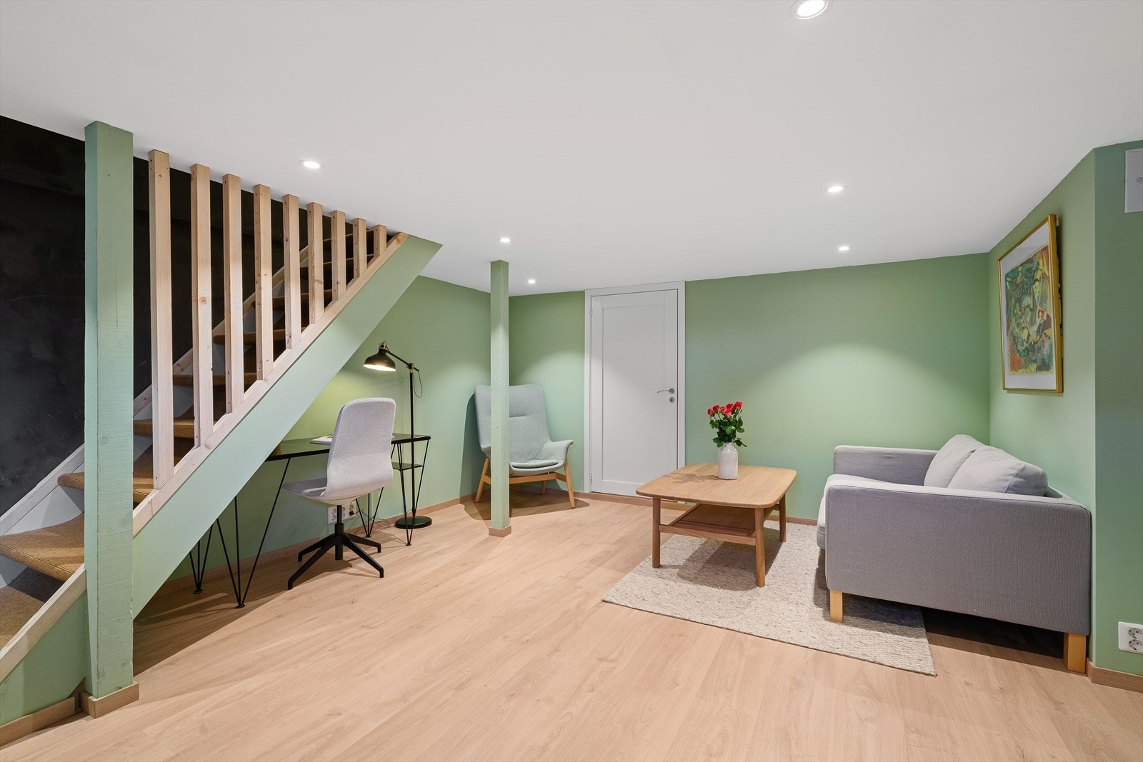 Romslig kjellerstue som består av lyse overflater på vegg og laminat på gulv. Galleribilde