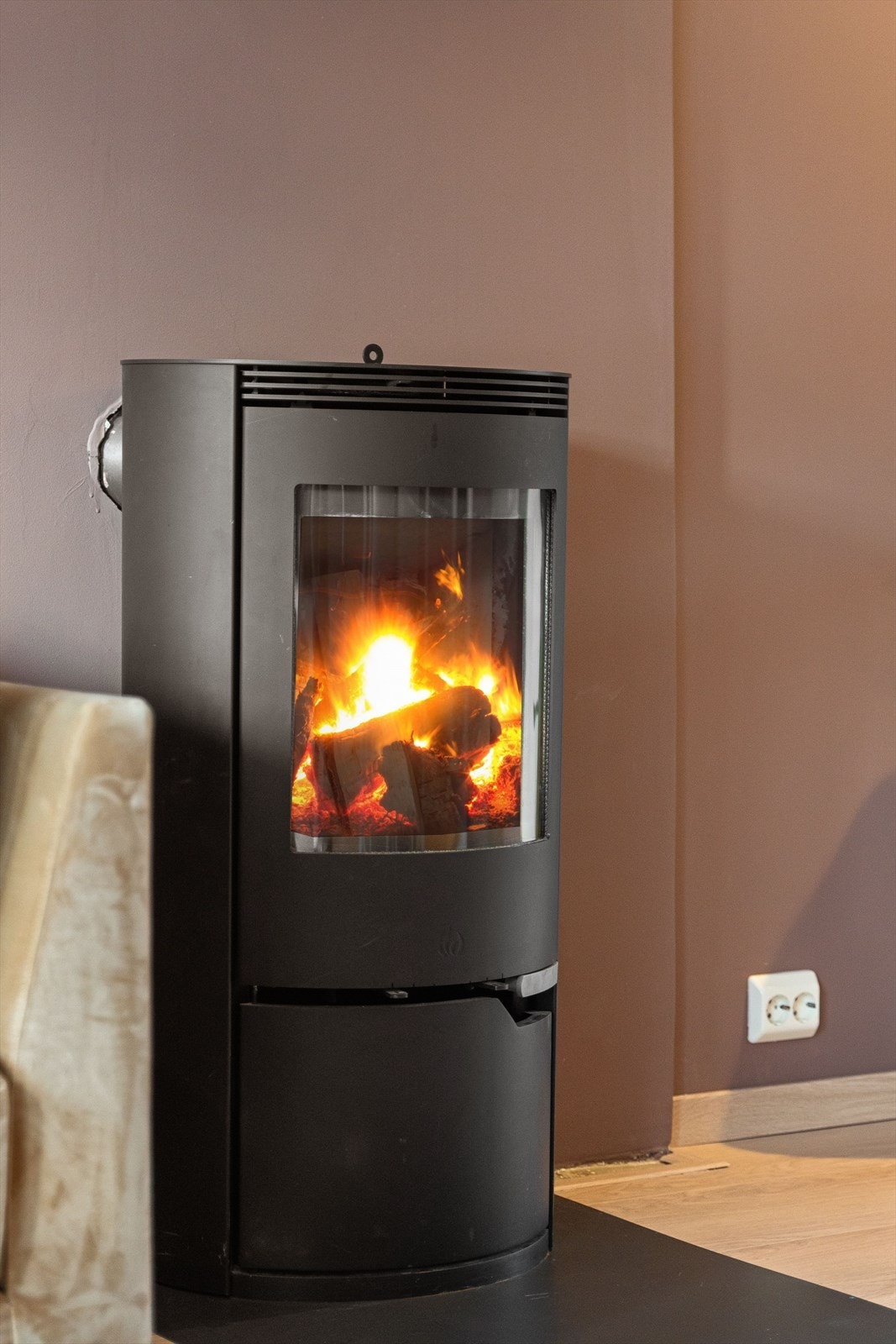 Peis-ovnen er plassert sentralt i rommet og byr på stemningsskapende varme når du tenner opp på kjølige dager. Galleribilde