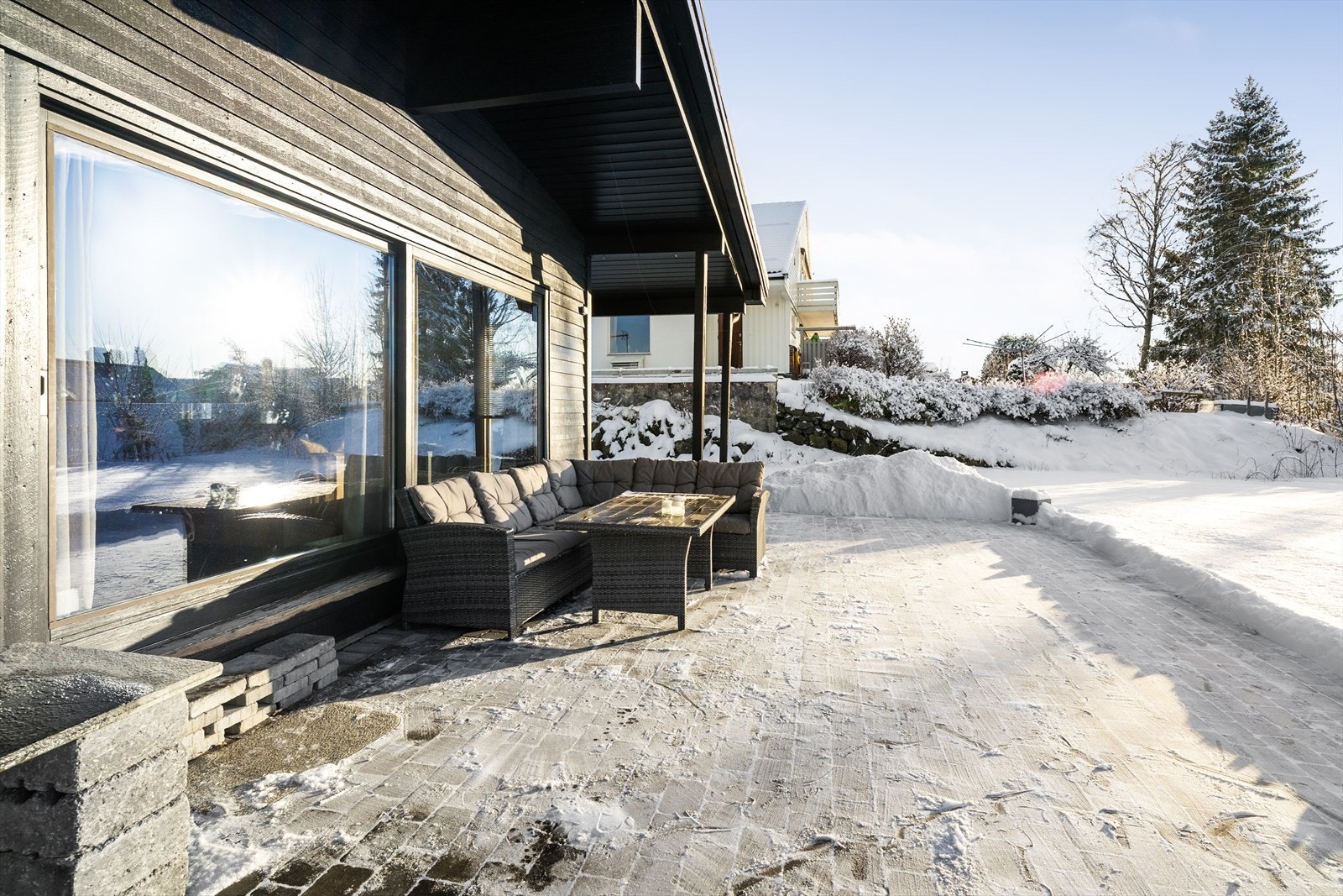 Solrik og vestvendt uteplass som er delvis overbygget og pent opparbeidet med belegningsstein. Galleribilde