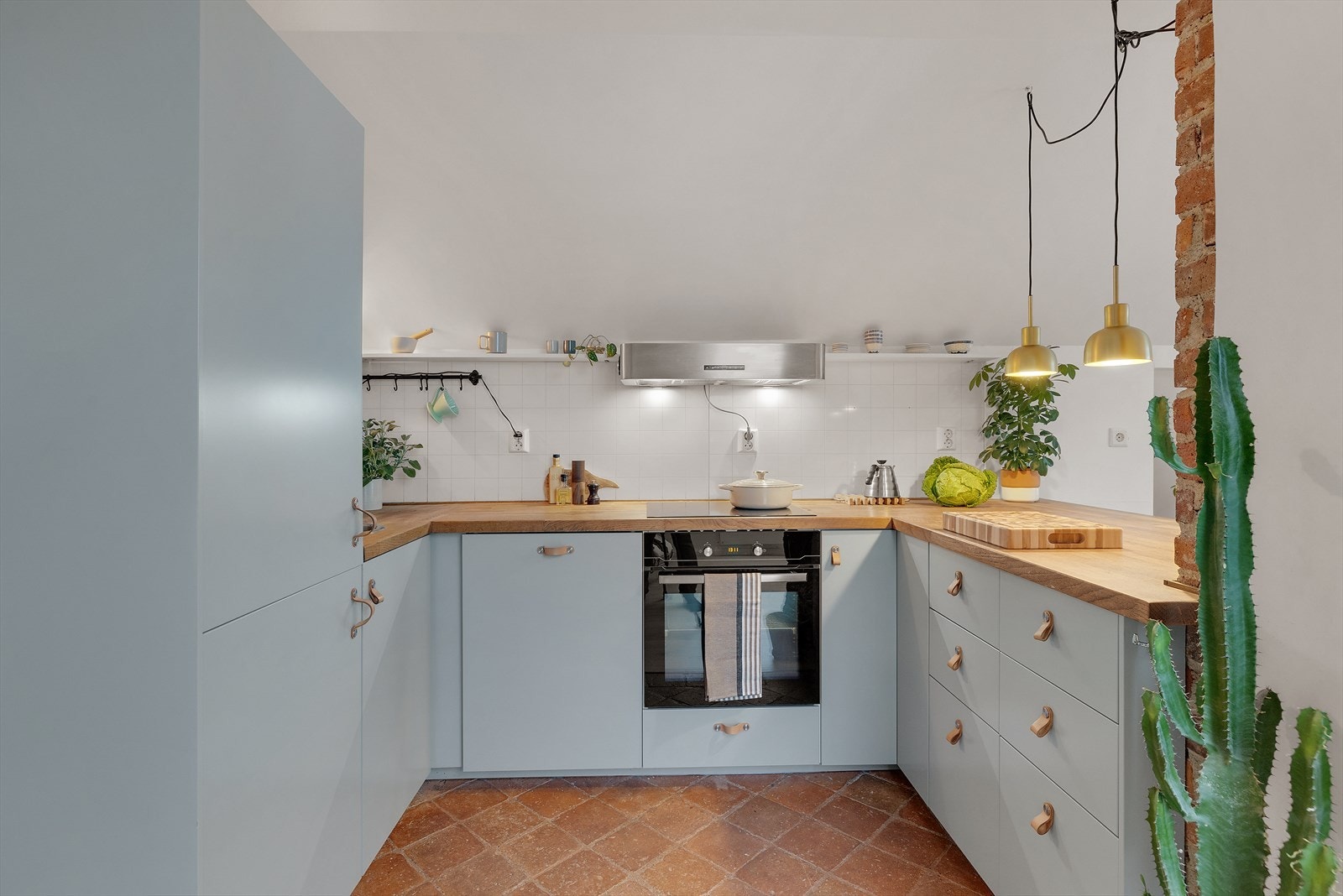 Kjøkkenet med glatte fronter i blåtoner fra 2017. Benkeplaten er i tre, og det er integrerte hvitevarer med induksjon platetopp, stekeovn, kombiskap (kjøl og frys) og oppvaskmaskin. Galleribilde