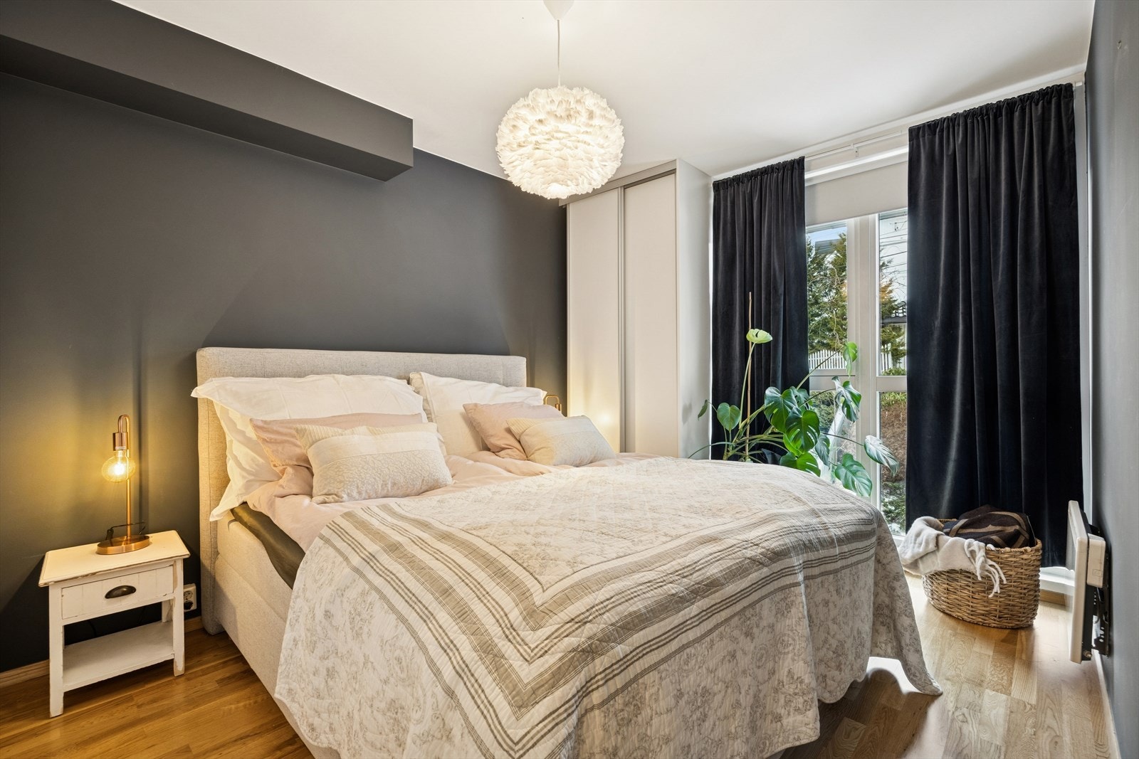 Romslig og delikat hovedsoverom med garderobeløsninger på begge sider av seng. Galleribilde