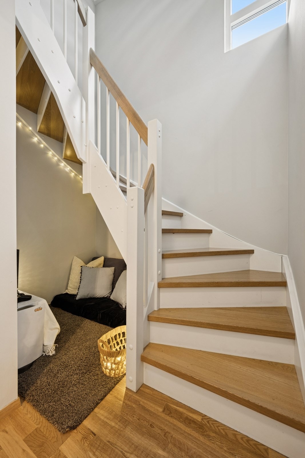Hvitmalt trapp med lakkerte eiketrinn og håndløper. Under trappen er det mulighet for liten lesekrok, hjemmekontor eller TV-krok Galleribilde