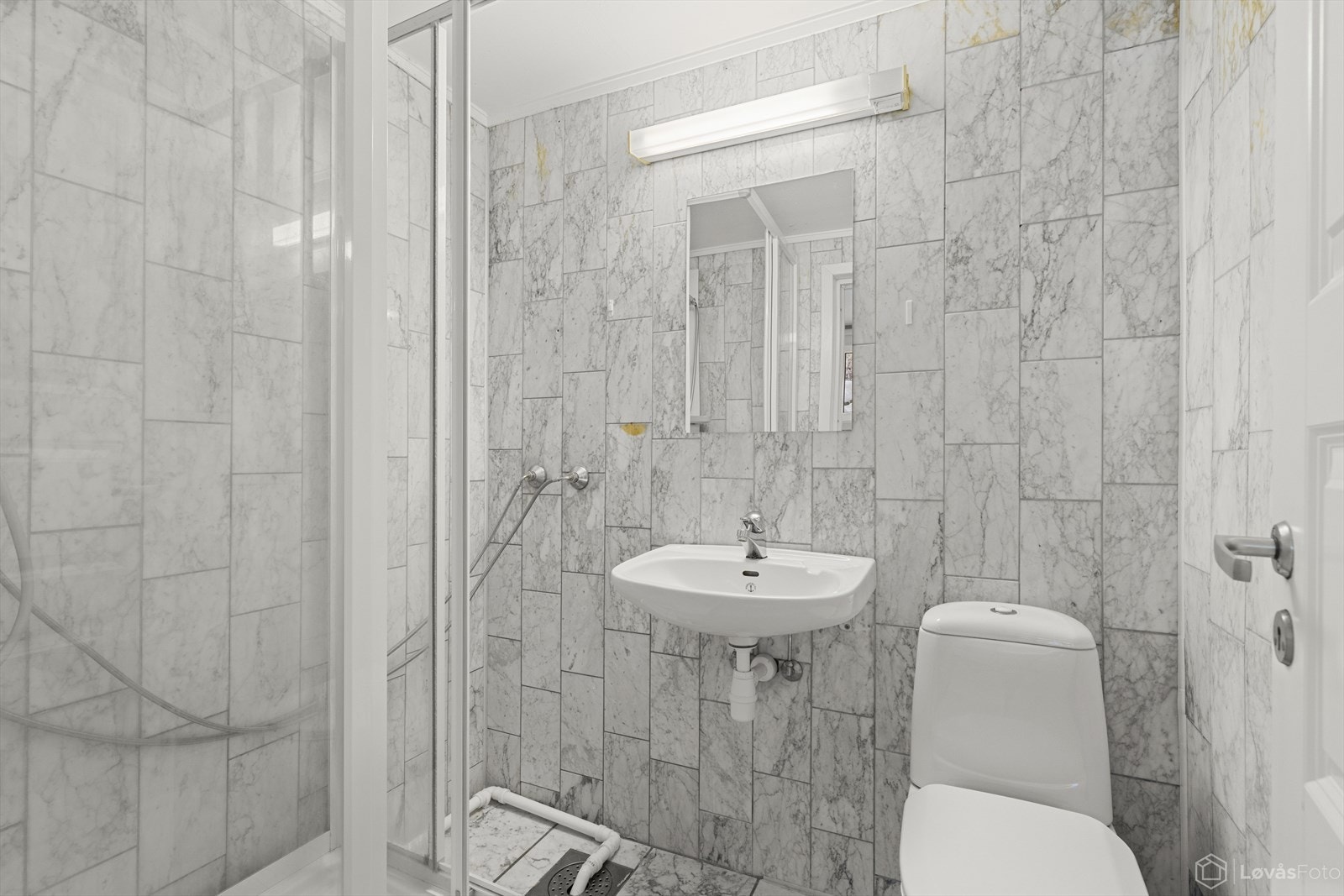 Det er totalt to bad og et toalett i underetasjen. Baderom 1 er innredet med dusjkabinett, klosett og servant. Galleribilde