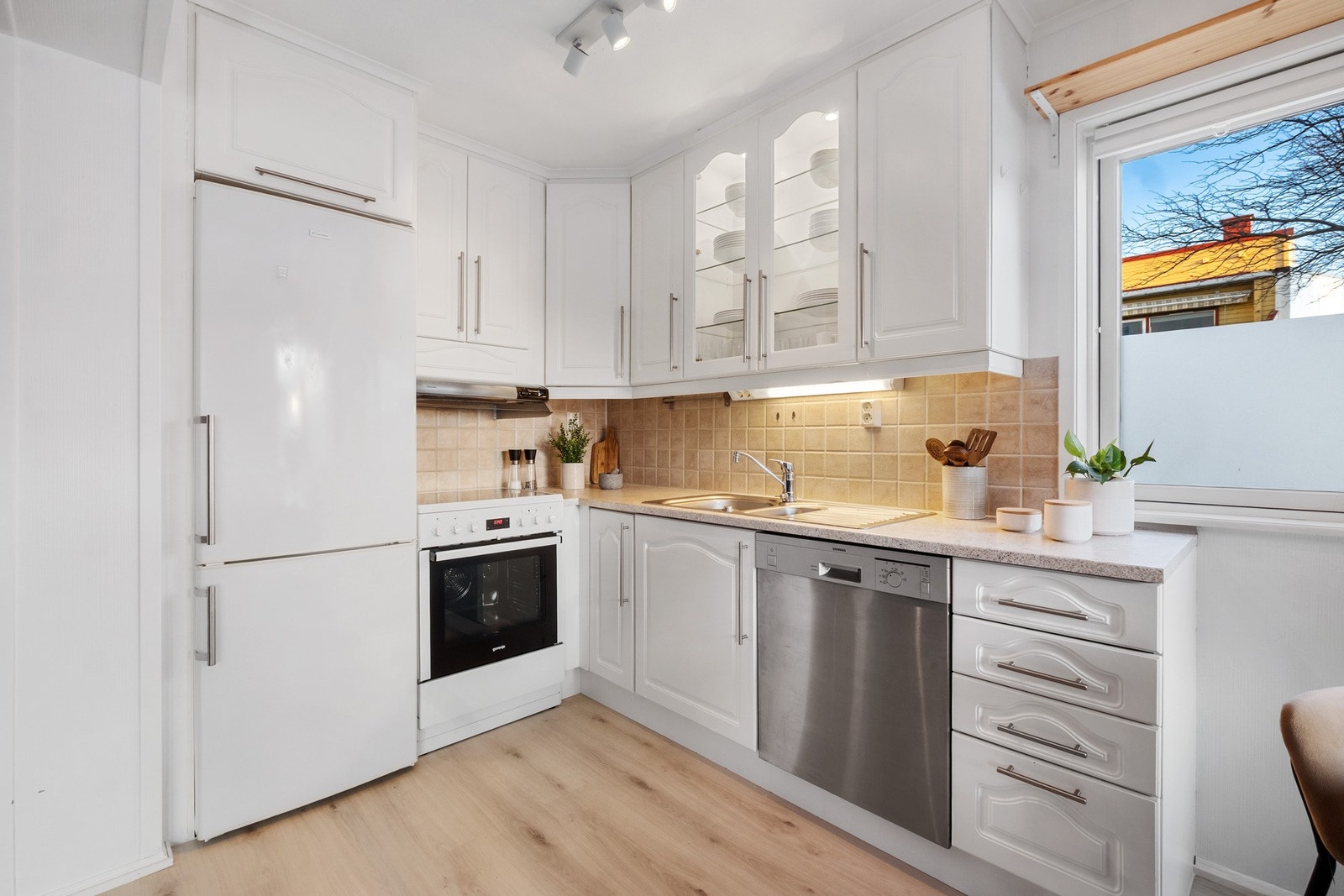 Praktisk kjøkken med hvite fronter og benkeplate i laminat Galleribilde