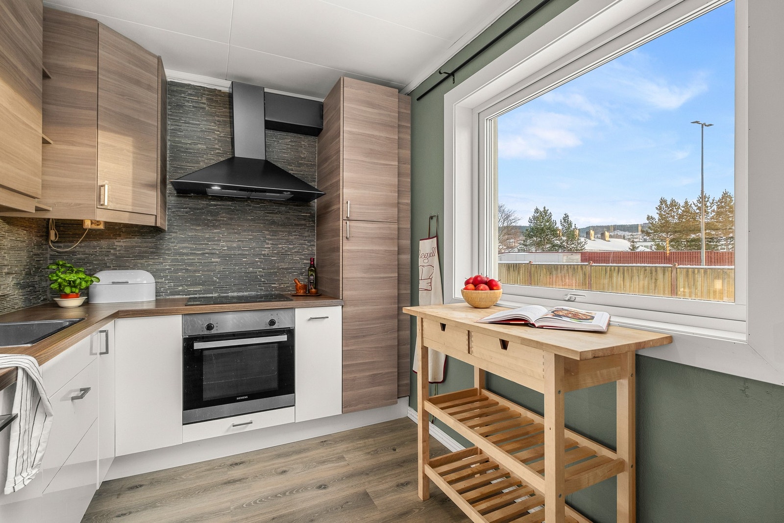 Kjøkkenet er innredet med integrert kjøleskap, oppvaskmaskin og stekeovn Galleribilde