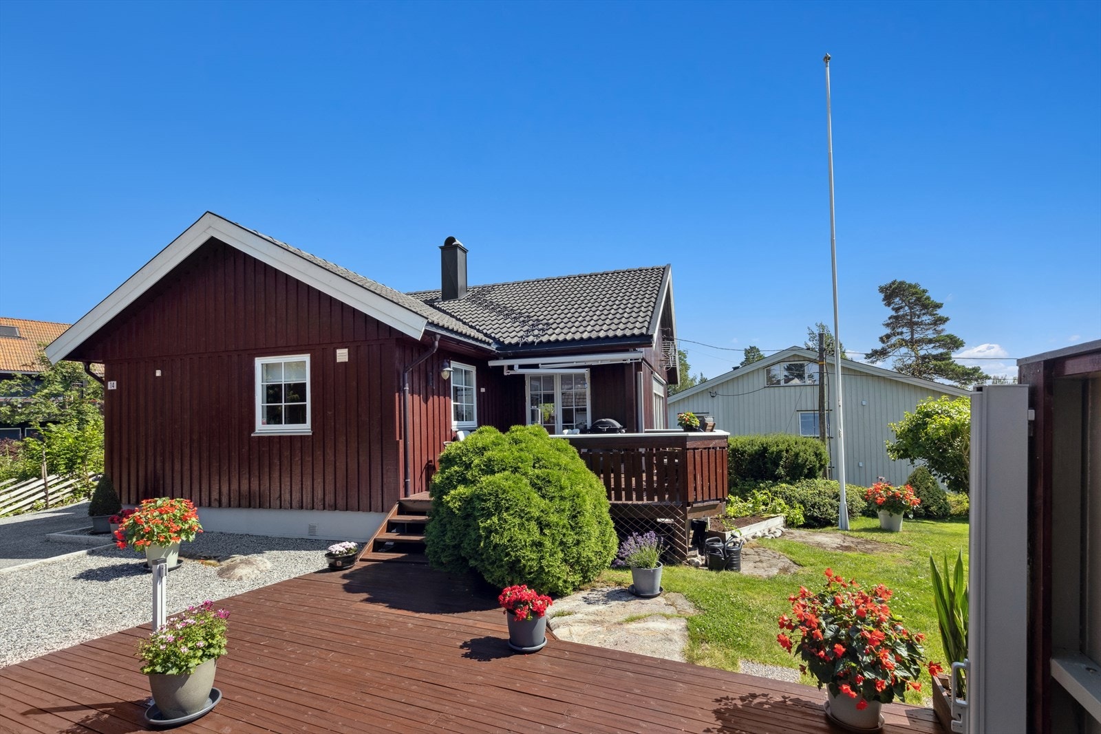 Solrik tomt som er pent opparbeidet med flere solrike uteplasser, gressplen, hekk, diverse beplanting og flaggstang. Galleribilde