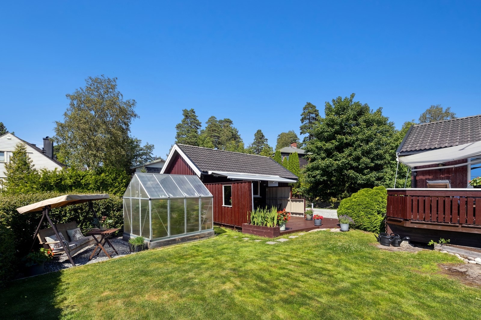 Fra terrassen er det lett tilgang til hagen med stor gressplen og diverse beplantning. Galleribilde