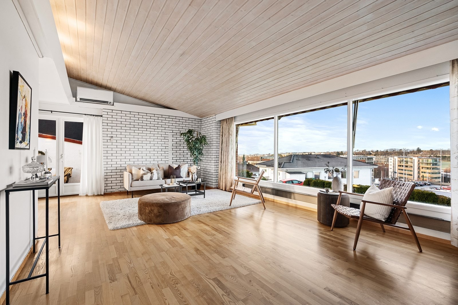 Lun stue med store vindusflater som slipper inn rikelig med dagslys. Galleribilde