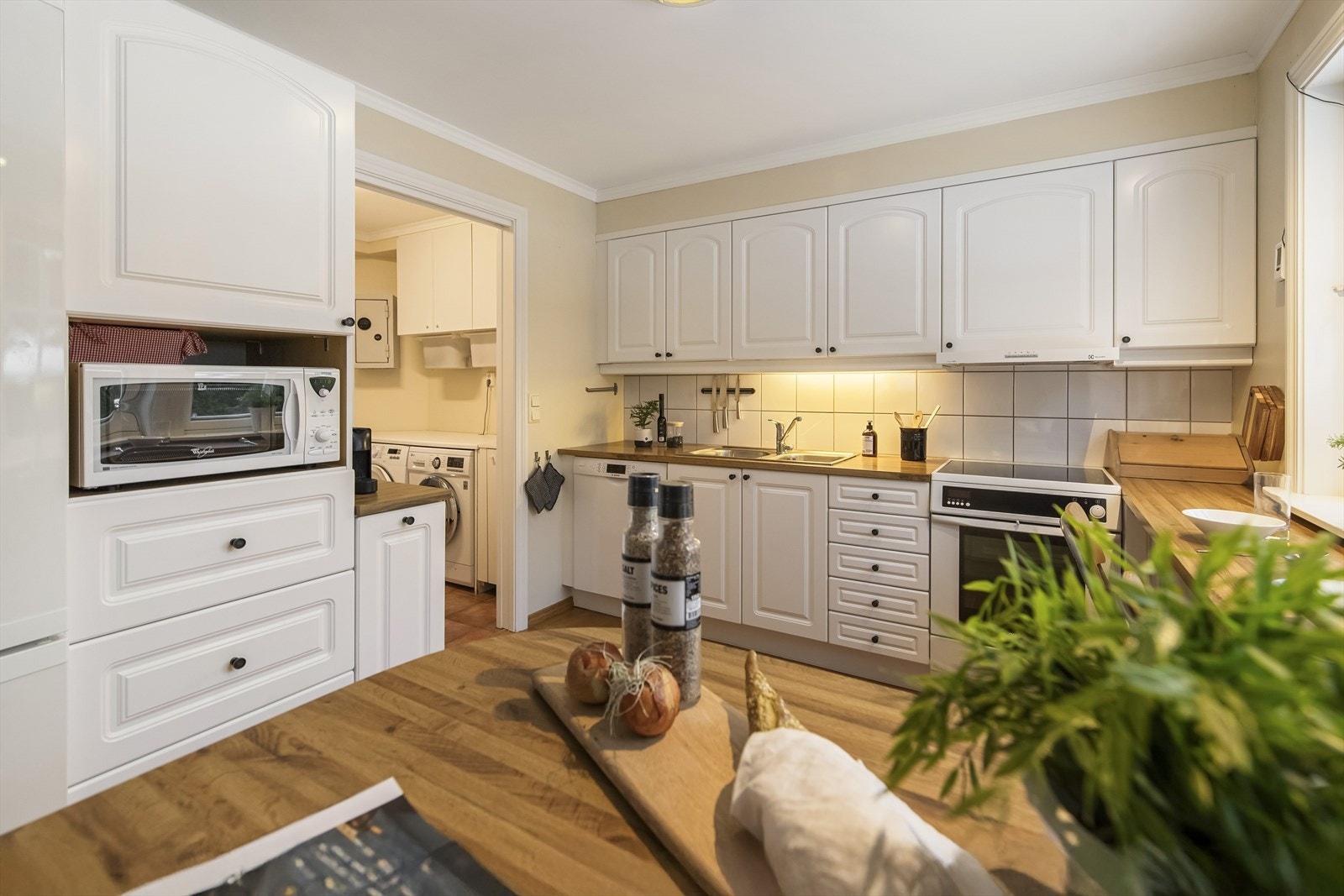 Kjøkkenet har profilerte fronter, ventilator og opplegg for oppvaskmaskin. Galleribilde