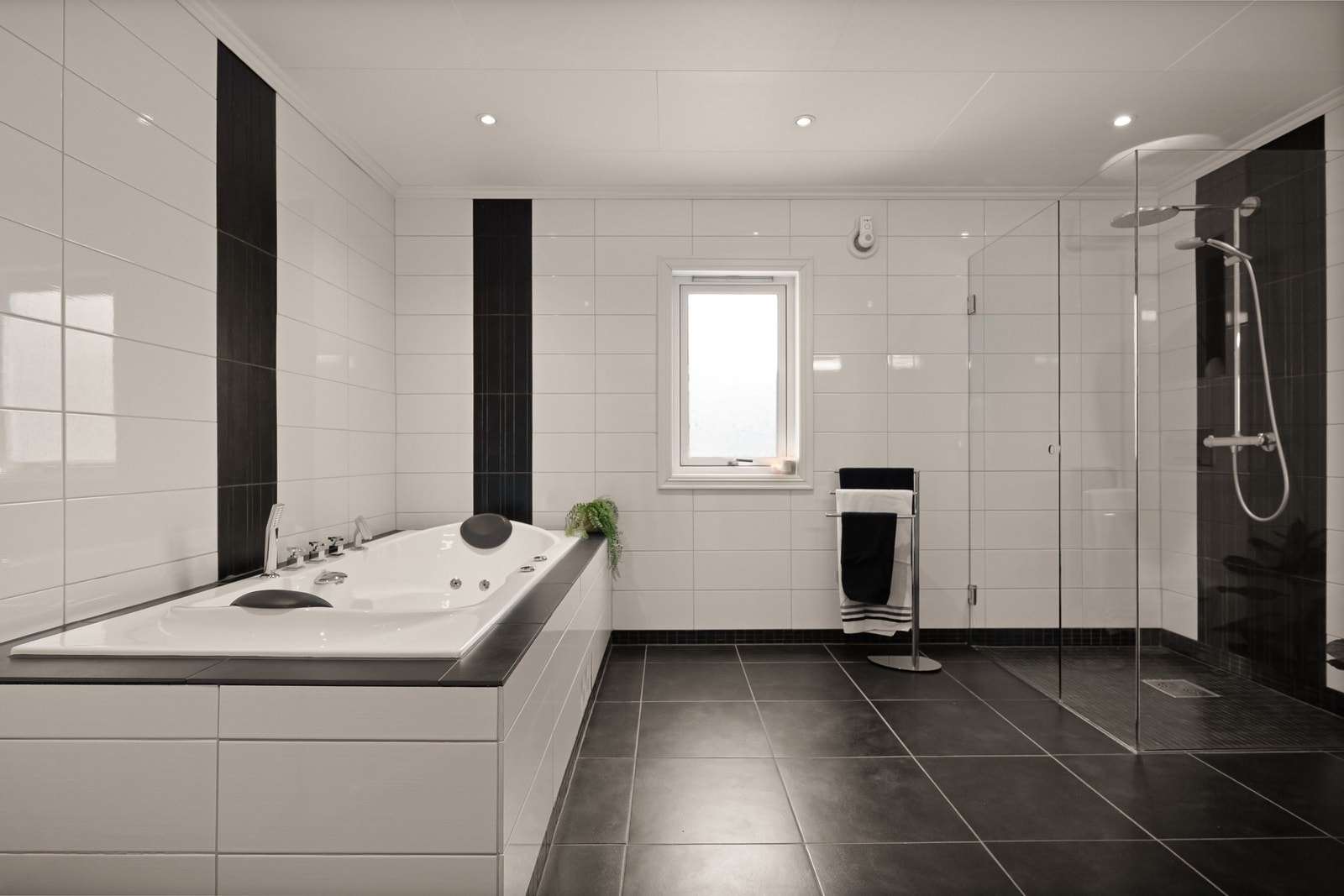 Flislagt bad med varmekabler, badekar og romslig dusj Galleribilde