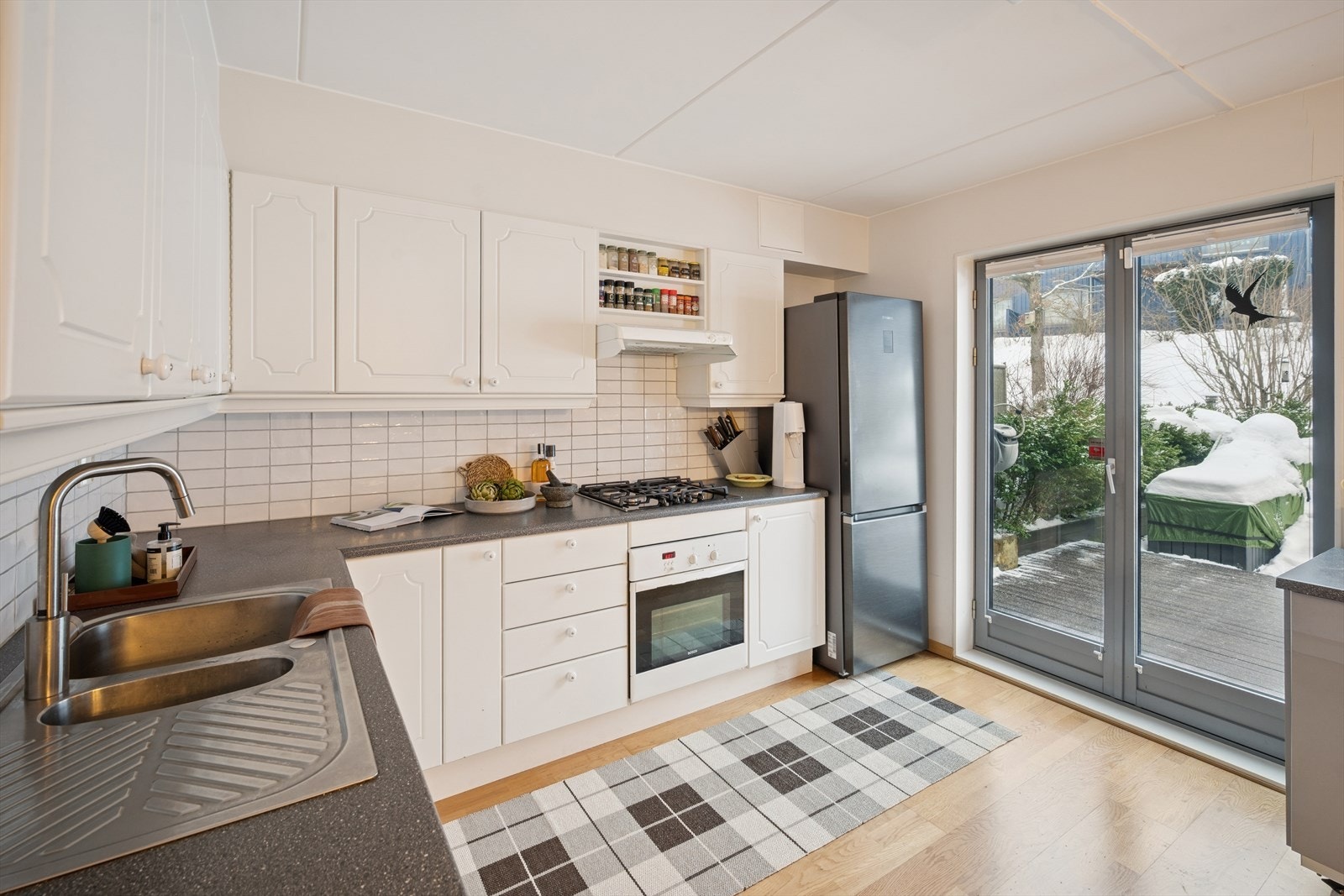 Kjøkken med klassisk innredning i hvite fronter og rikelig med skap- og benkeplass. Utstyrt med stekeovn og gasskoketopp. Galleribilde