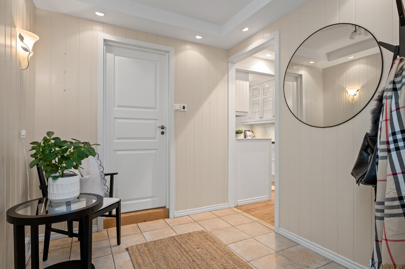 Fra en innbydende entré med flislagt gulv ledes du videre inn i leiligheten. Det er stedvis innfelte downlights i taket for god lyssetting. Galleribilde