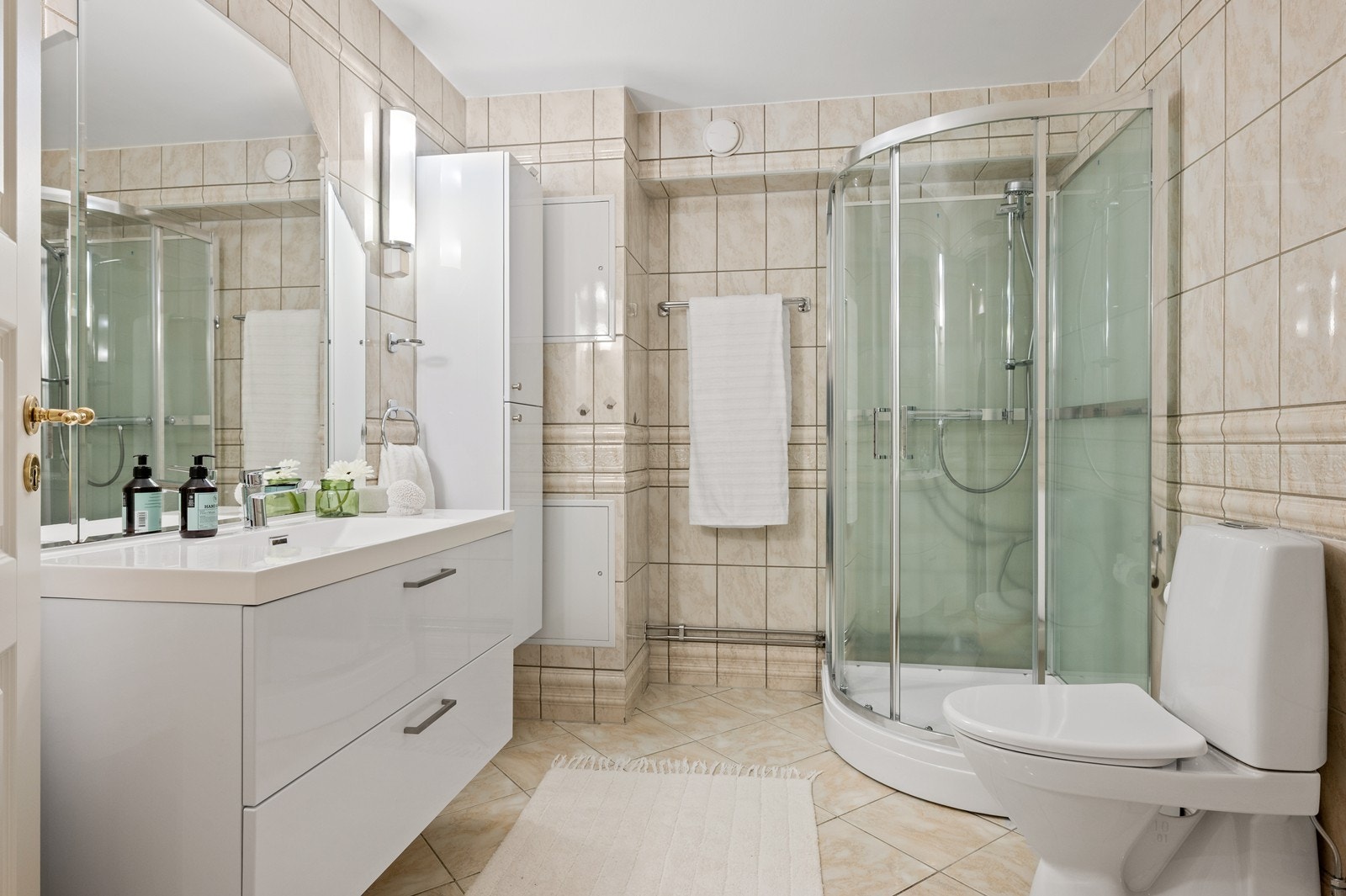 Baderommet har oppgraderte overflater fra 2000, er helfliset med varme i gulvet, og nylig har det blitt satt nytt dusjkabinett, og ny stilren servantinnredning med lagringsplass i skuffene og ekstra høyskap for lagring. I tillegg er det gulvmontert wc. Galleribilde