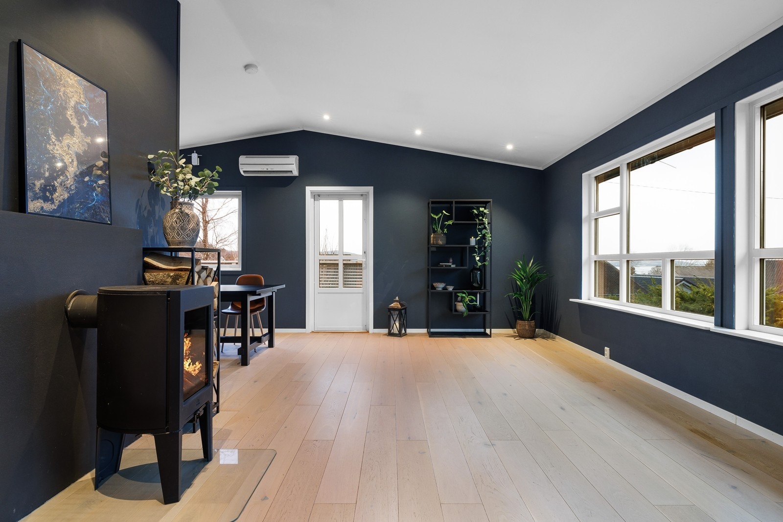 Lun atmosfære med vedovn, varmepumpe og spotter i himling. Galleribilde