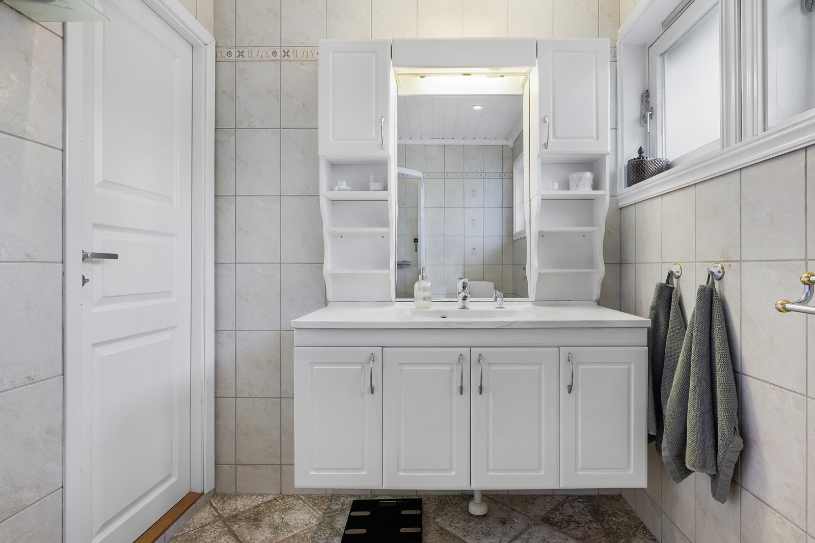 Helfliset bad med romslig oppbevaringsplass rundt servant. Galleribilde