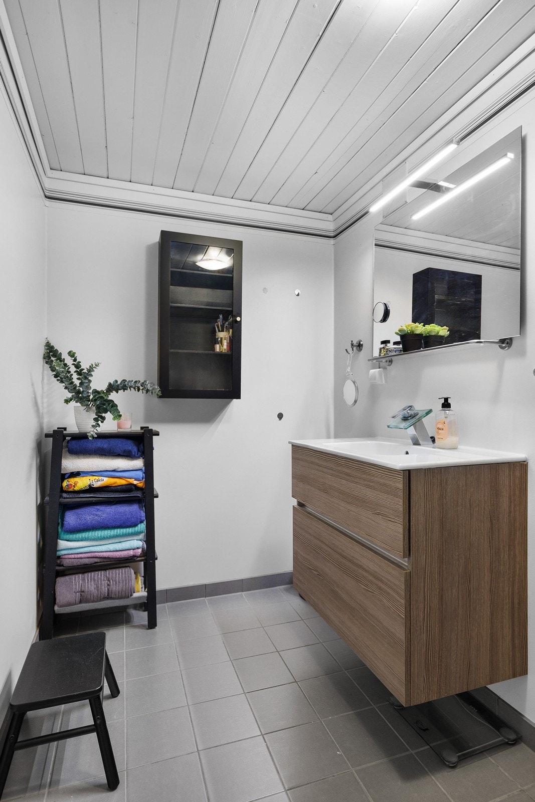 Delikat bad med helstøpt servant, skuffer og speil med belysning. Galleribilde