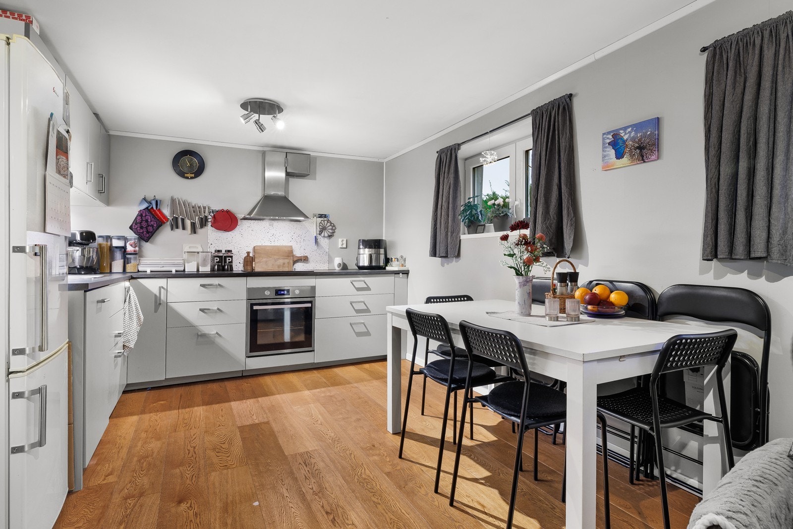 Kjøkken i lune gråtoner med stålhåndtak og godt med skapplass. Galleribilde