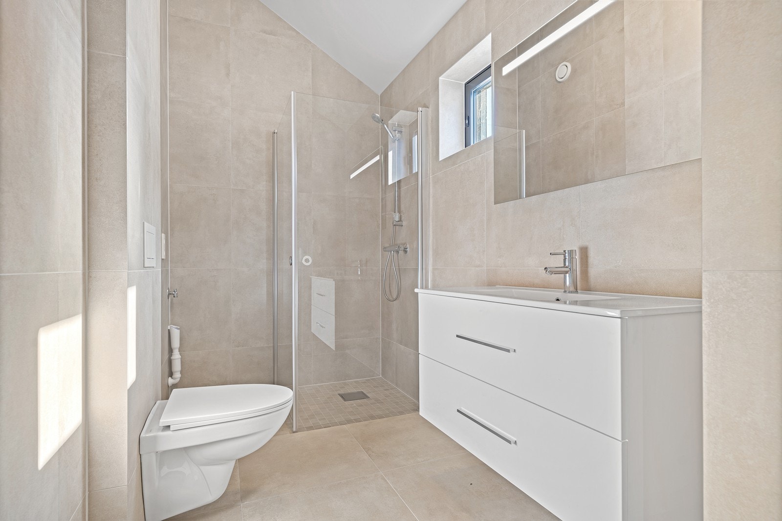 Bad i praktikantdel - opplegg for vaskemaskin og innredet med dusjhjørne, servant og vegghengt toalett Galleribilde