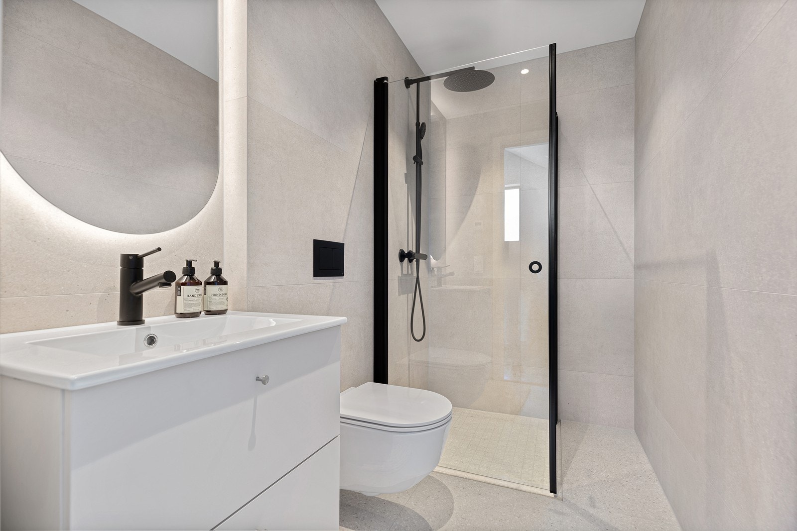 Bad som er tilknyttet hovedsoverommet - innredet med dusjhjørne, vegghengt toalett og servant med skap. Galleribilde