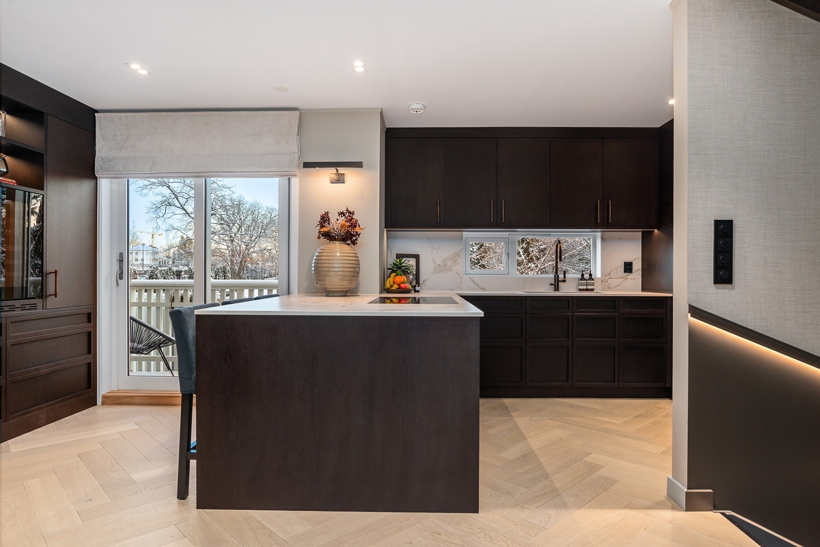 Snekkerbygd kjøkkeninnredning med romslig og sosial kjøkkenøy og god plass til matlaging og måltider Galleribilde