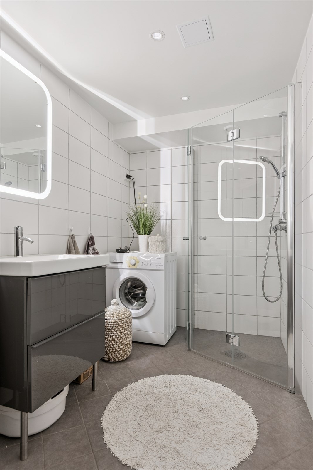 Baderomsinnredningen inkluderer servant med underskap og speil med integrert belysning. Galleribilde