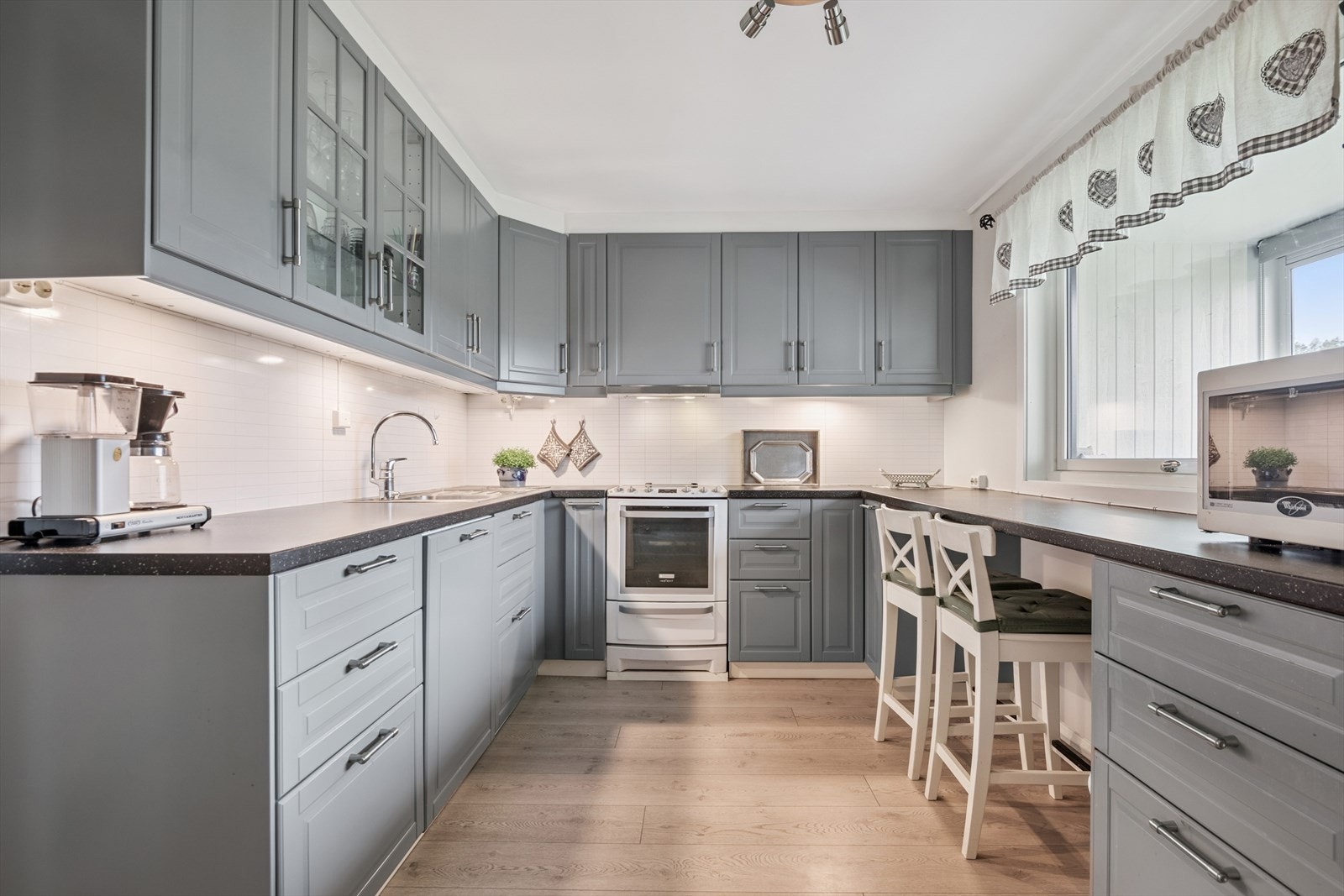 Innredningen byr på smarte løsninger med blant annet vitrineskap og god belysning over benk. Galleribilde