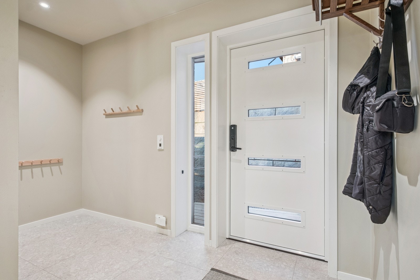 Lys og praktisk entrè med flislagt gulv med varme Galleribilde