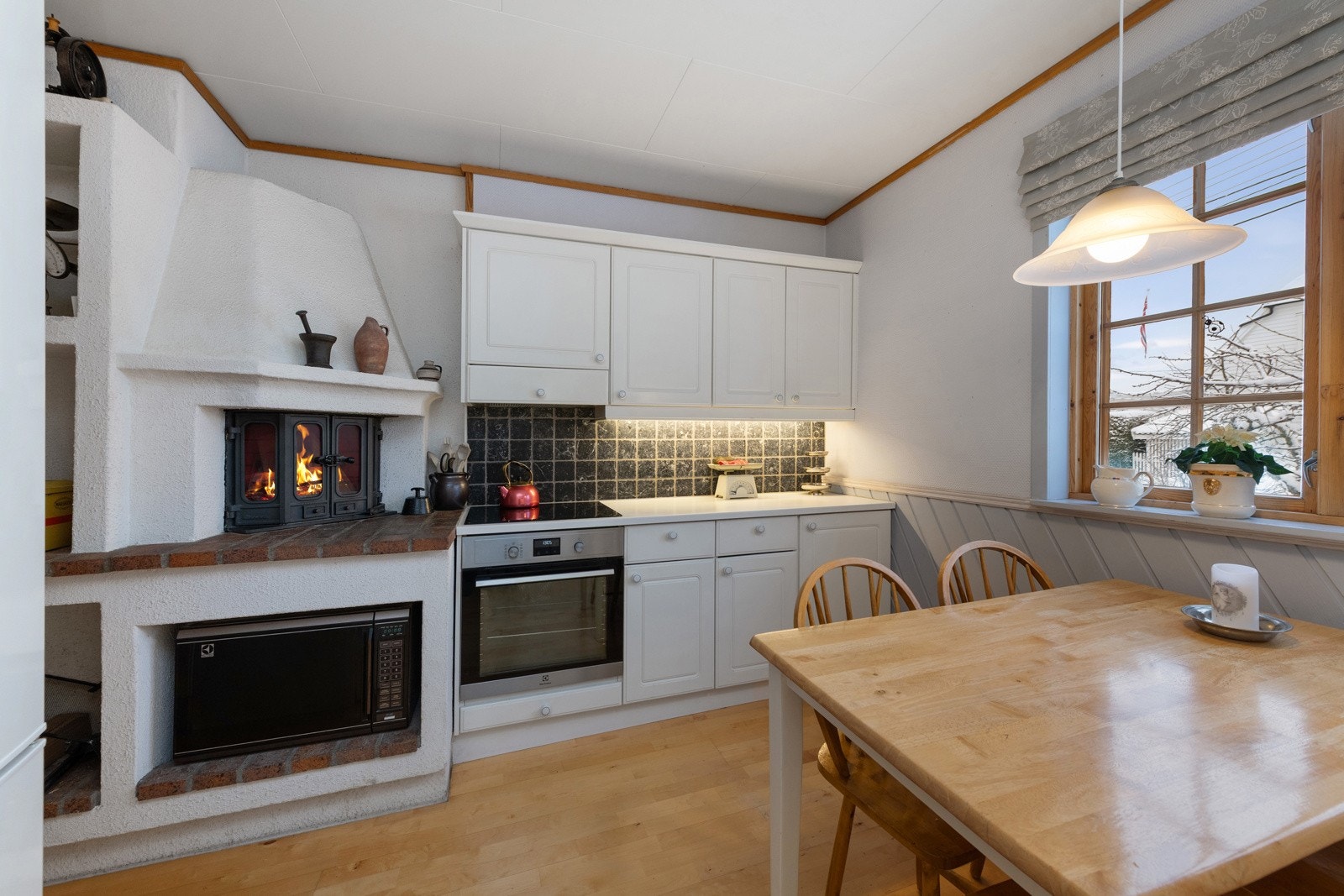 Kjøkken var plass til spisebordet ved vindu. Peis setter sitt koselige preg på rommet. Galleribilde