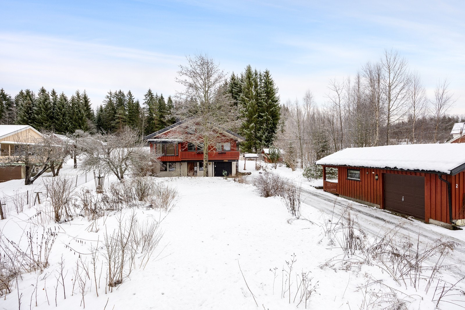 Parkering kan gjøres i den integrerte garasjen på ca. 30 kvm i underetasjen - eller den frittstående garasjen, som har elektrisk port. Galleribilde
