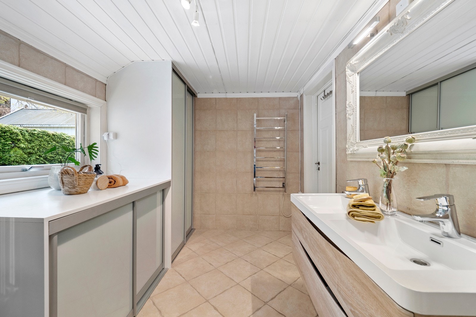 Baderommet er innredet med servantinnredning med dobbel vask, innredning med garderobe, dusjkabinett og wc Galleribilde