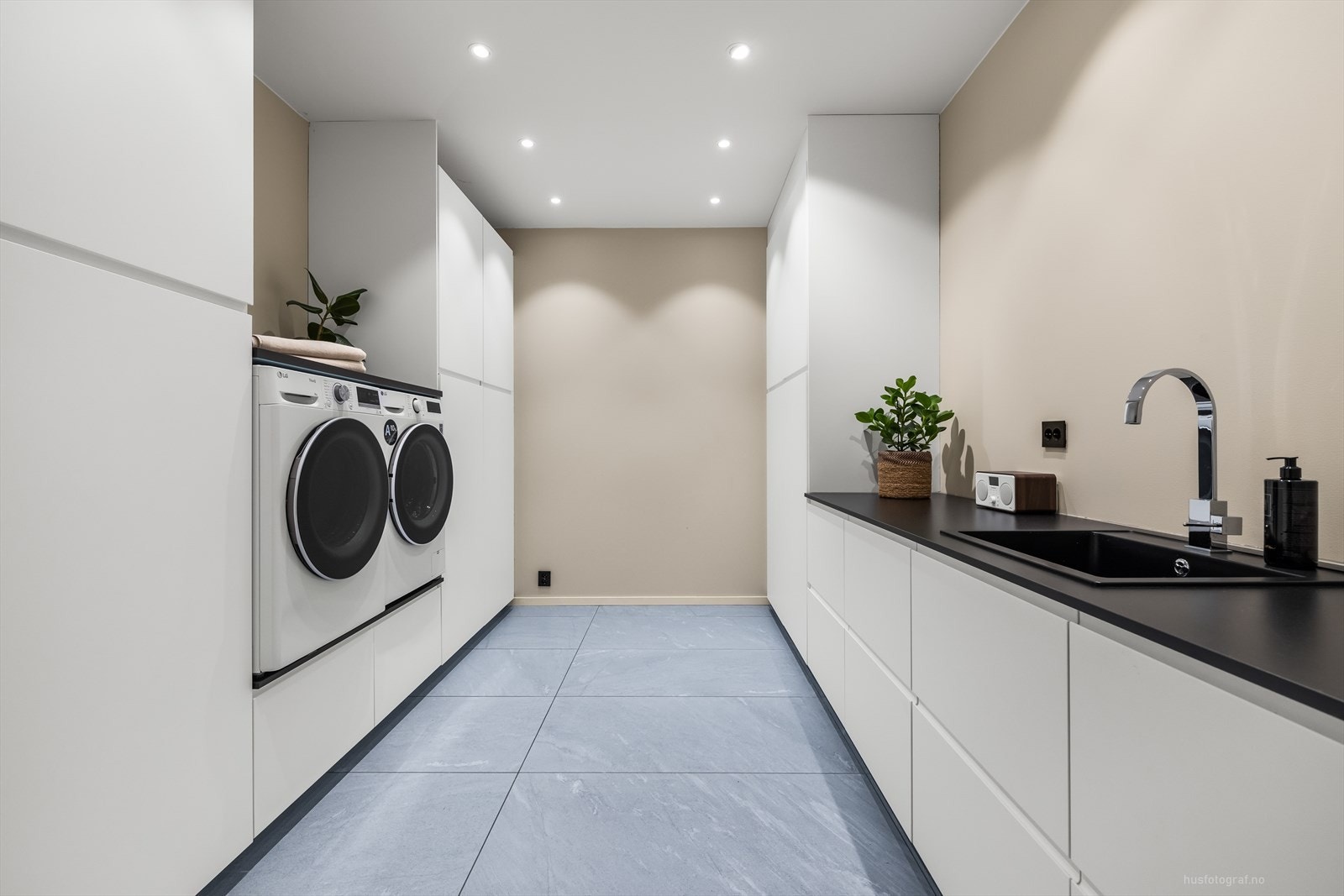 Praktisk og moderne innredet vaskerom i underetasjen med romslig innredning og opplegg for vaskerom og tørketrommel. Galleribilde