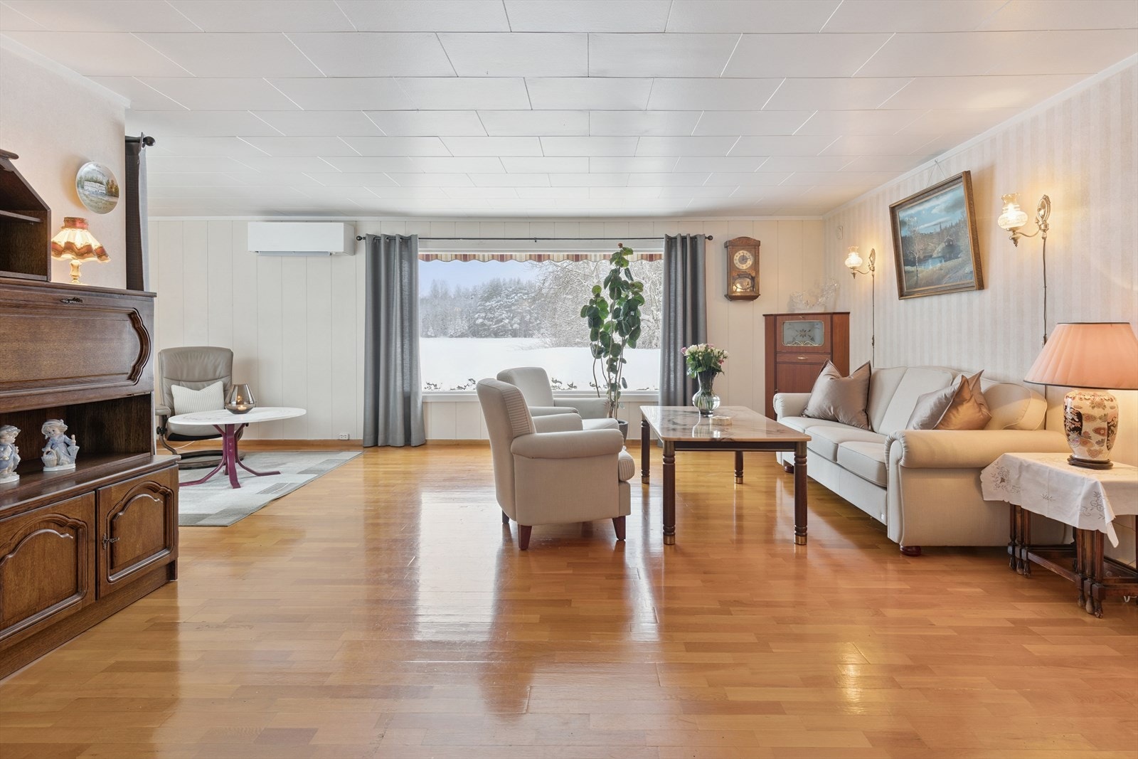 Stuen er romslig med parkettgulv og en nyere luft-til-luft varmepumpe installert i 2024. Galleribilde