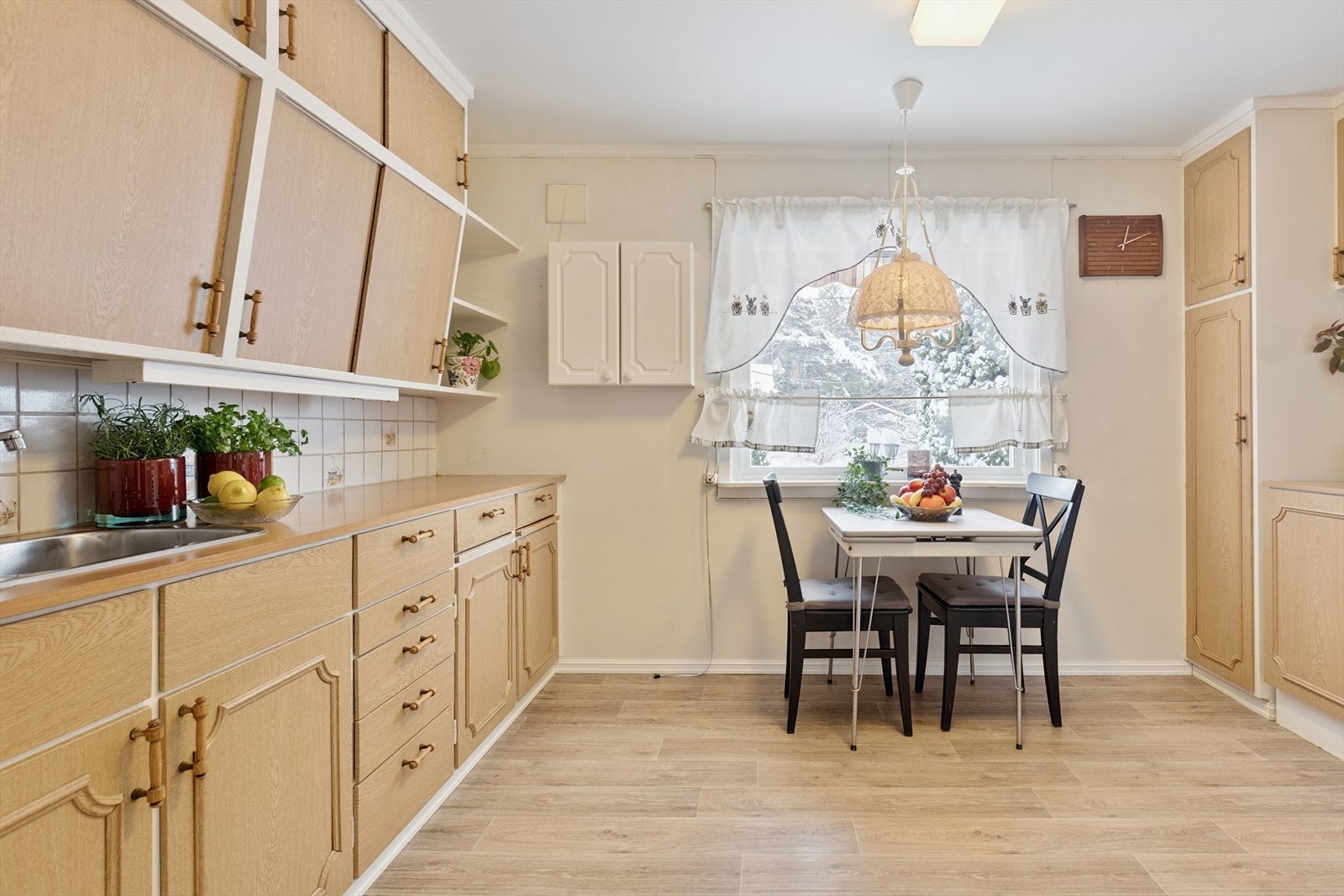 Innredningen har laminat benkeplater og fliser mellom benk og overskap. Galleribilde