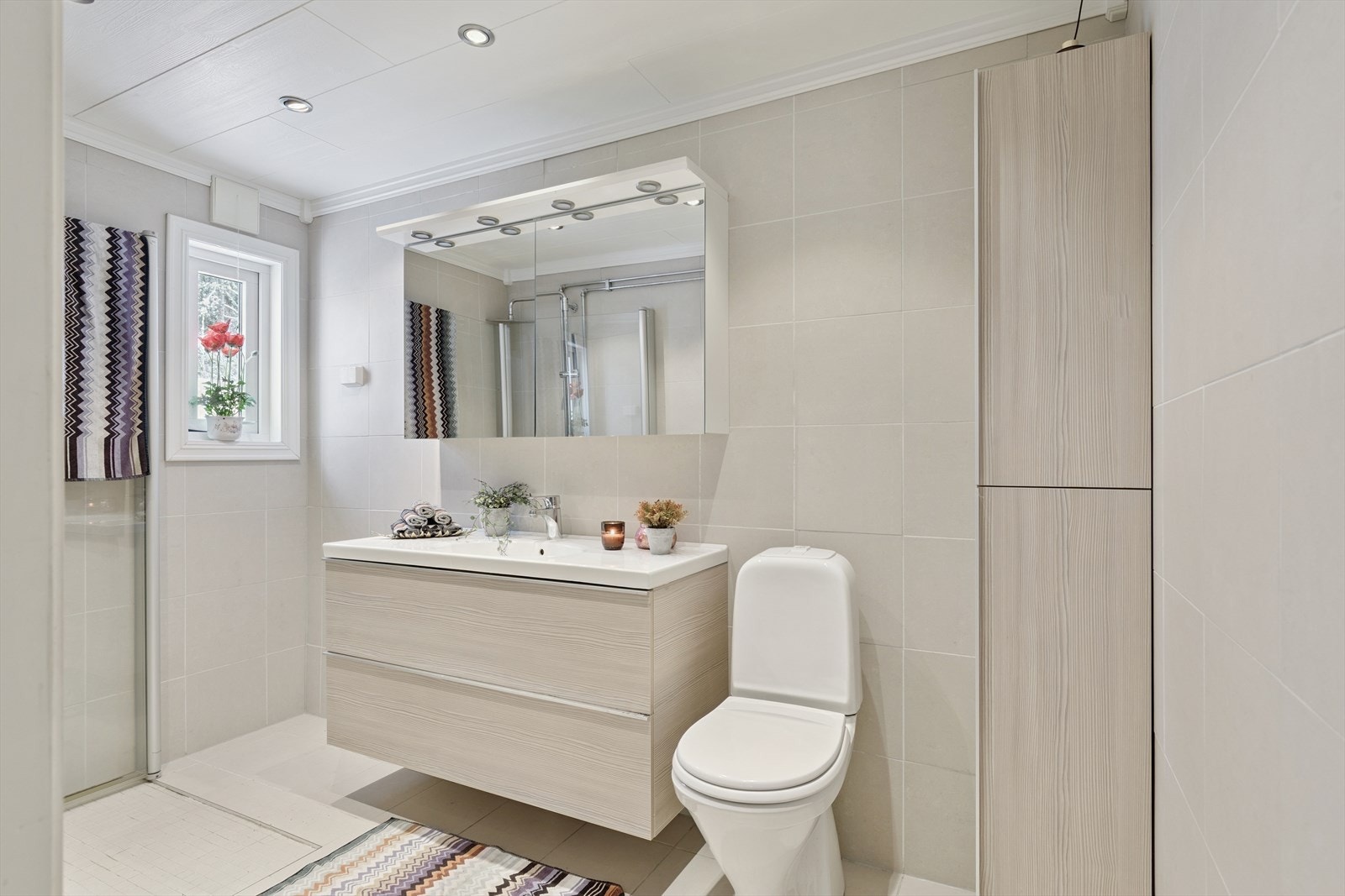 Tidsmessig, flislagt bad fra 2013 med vegghengt innredning og downlights i taket. Galleribilde