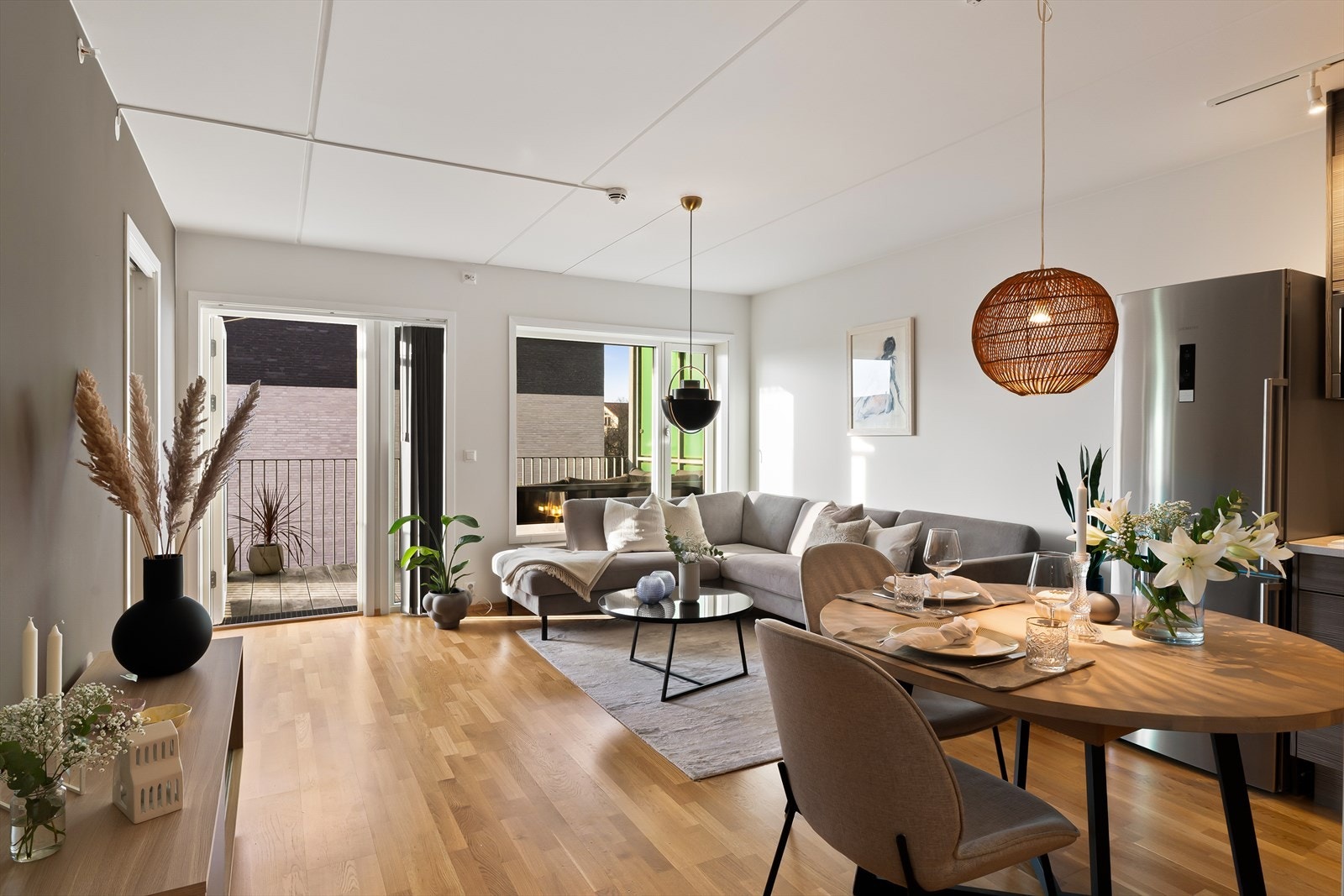 Stue, spisestue og kjøkken i åpen løsning med parkett på gulv og lysmalte flater Galleribilde