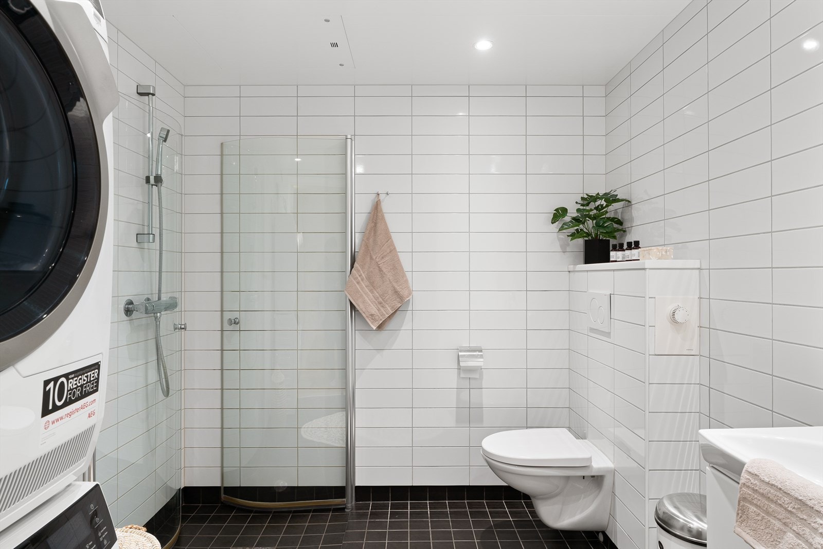 Pent kombinert bad og vaskerom med fliser og gulvvarme Galleribilde