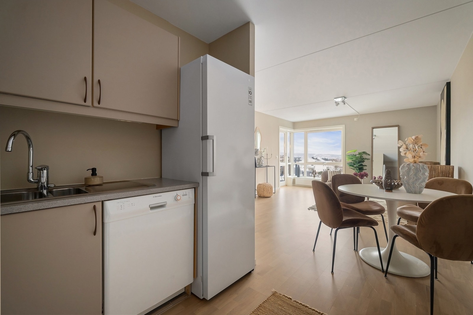 Stuen har en åpen løsning med kjøkkenet som skaper et sosialt oppholdsrom Galleribilde