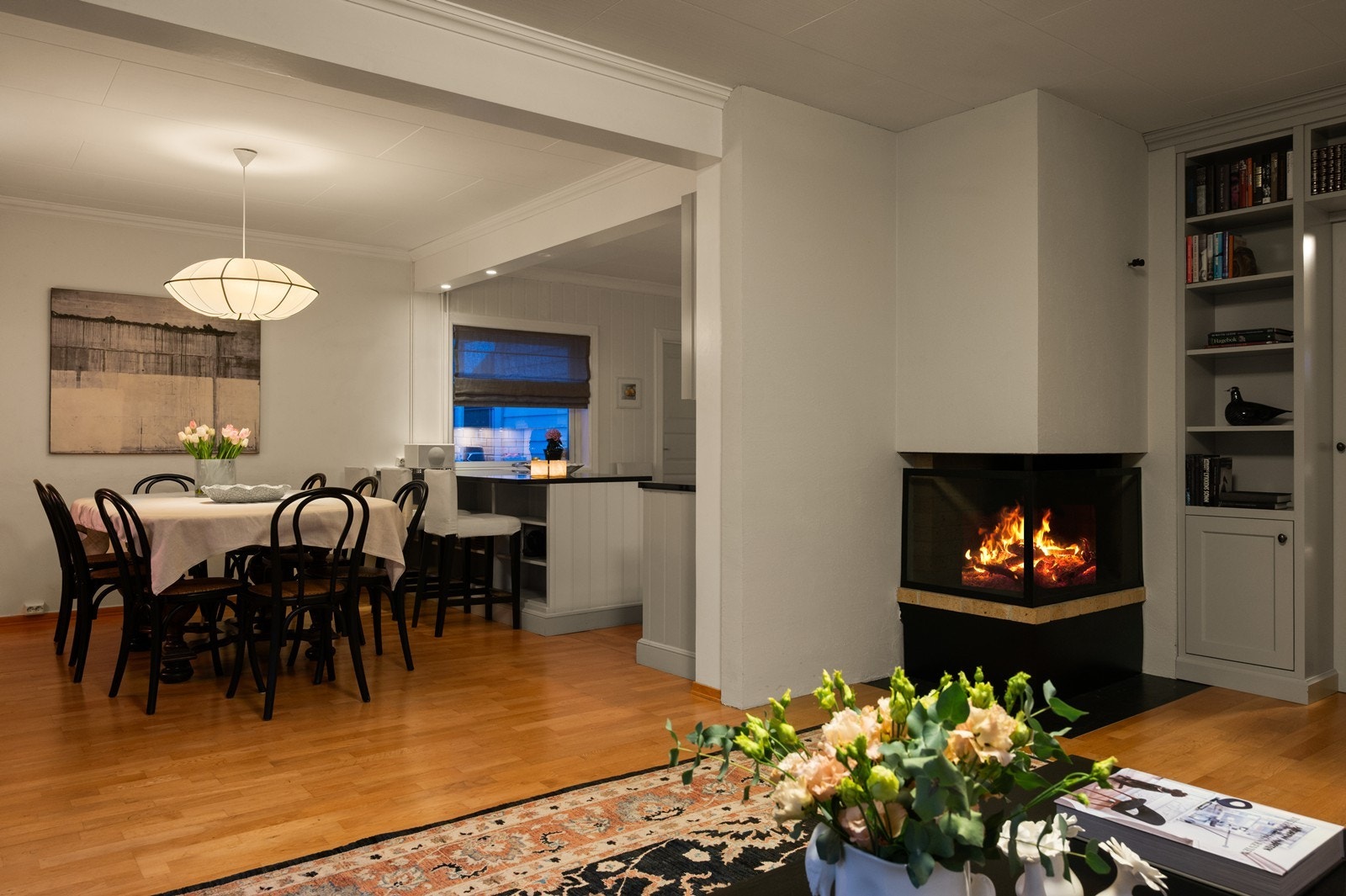 Fra spiseplassen ser man peisen i stuen, som bidrar med varme og atmosfære. Galleribilde