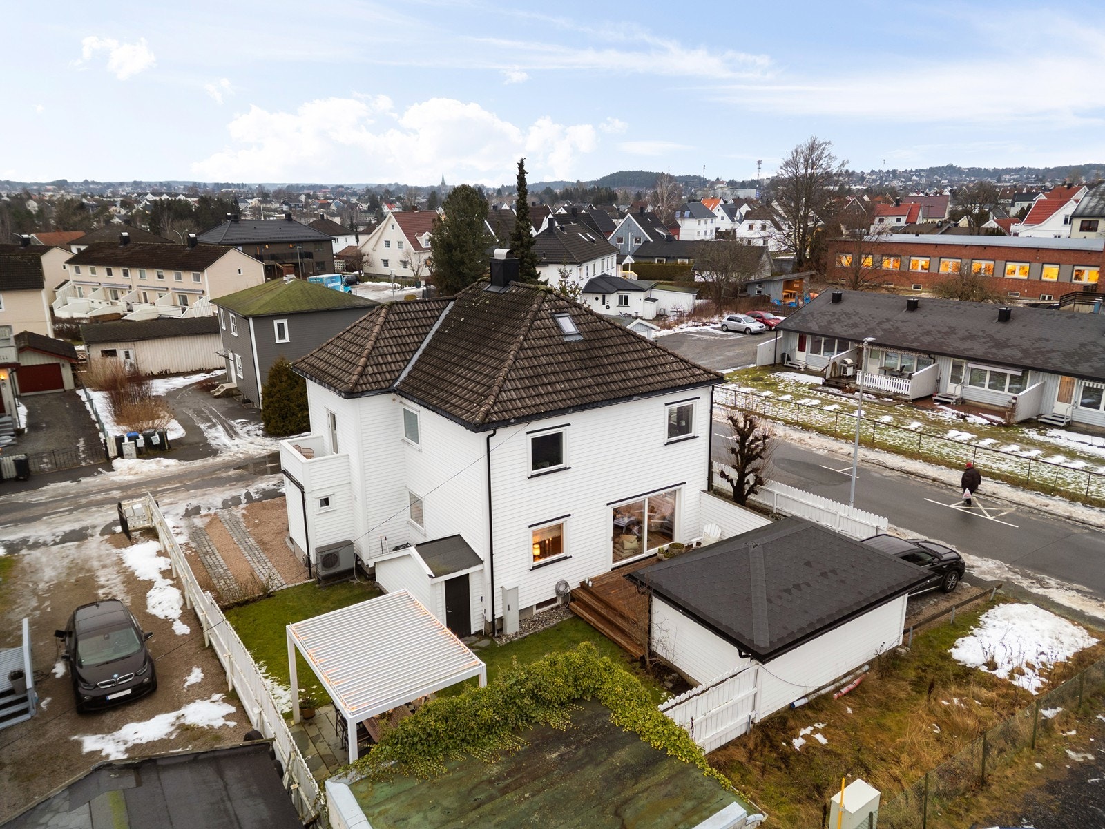 Eiendommen presenterer seg med en klassisk fasade, en velstelt hage og egen garasje. Galleribilde