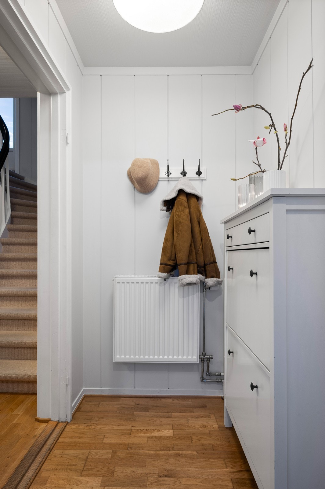 Ankomst via vindfang, med plass til skoskap og knaggerekke for oppheng av yttertøy. Galleribilde