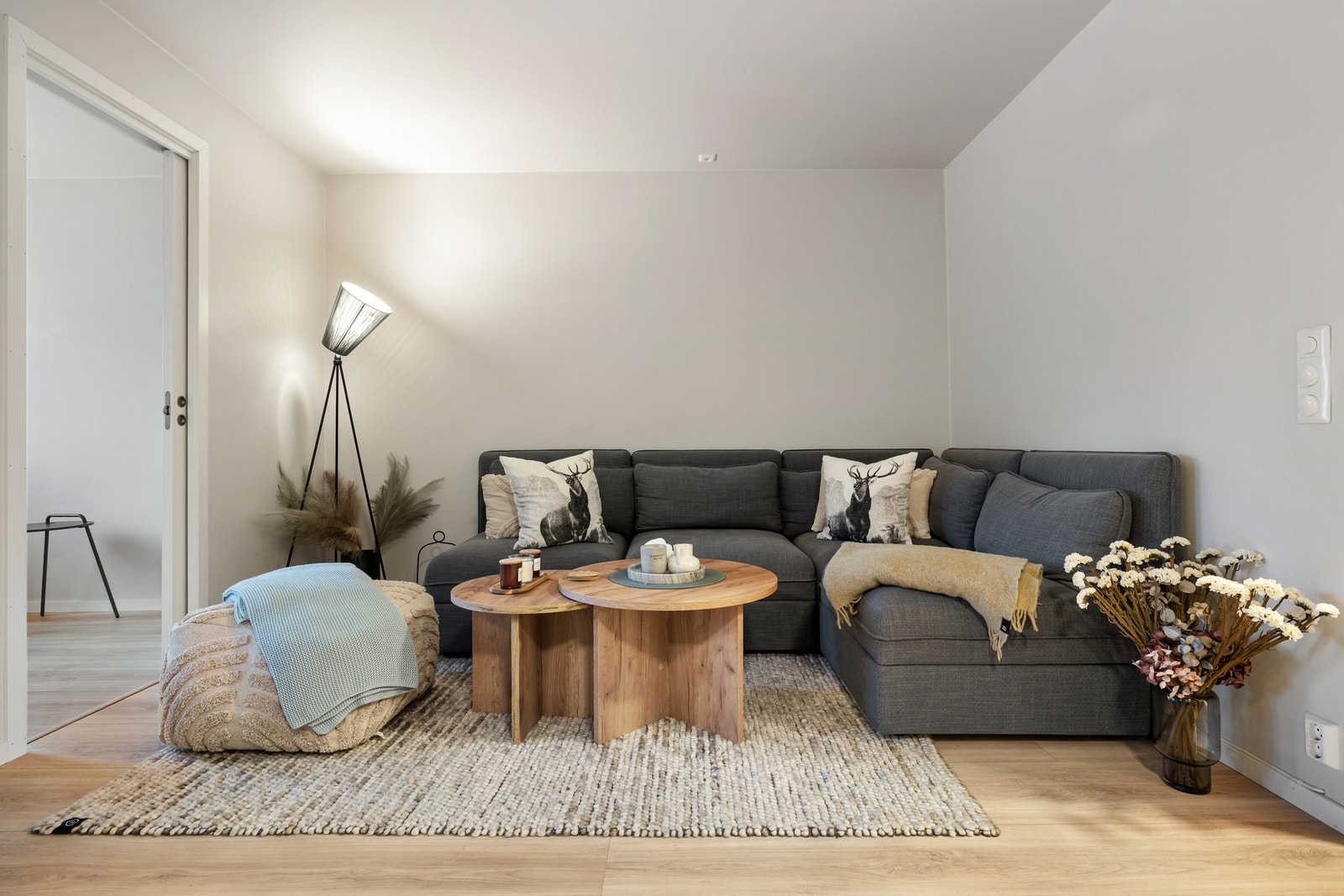 Leiligheten har en innbydende stue med lysmalte flater og en enstavs laminat på gulvet. Galleribilde