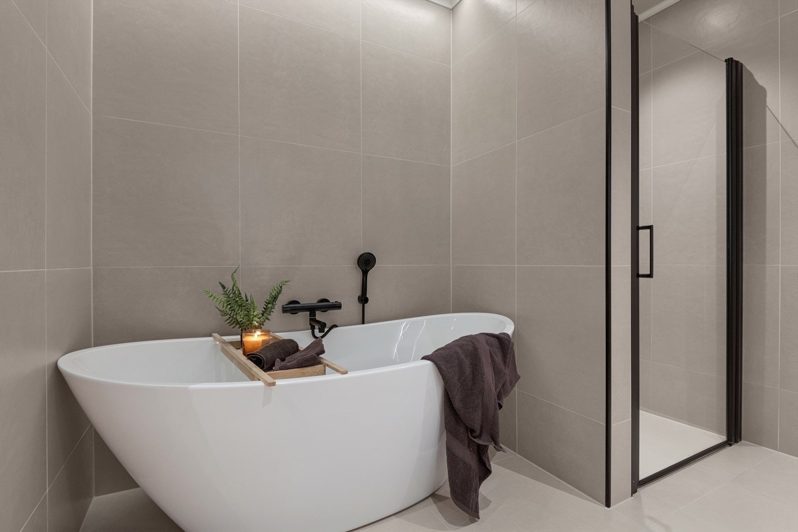 Baderommet er innredet med vegghengt toalett, innredning med heldekkende vask, badekar og dusjsone med glassdør. Galleribilde