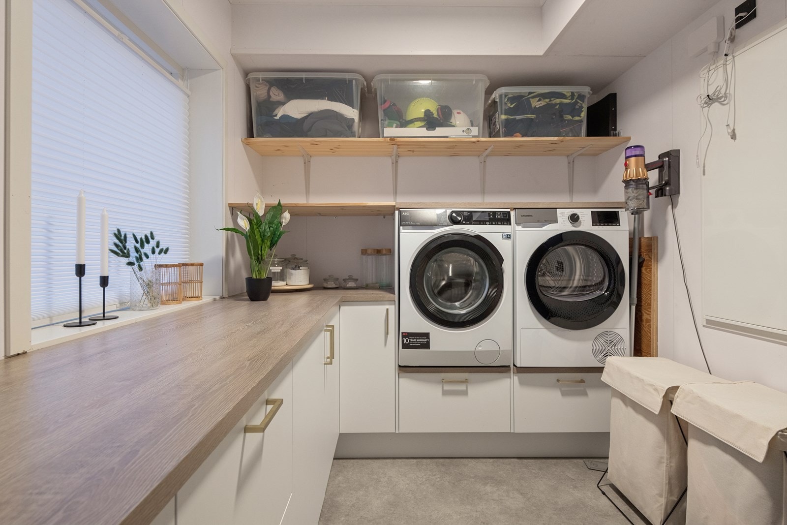 Vaskerommet er meget praktisk innredet med skap, benkeplass og opplegg for vaskemaskin og tørketrommel. Galleribilde