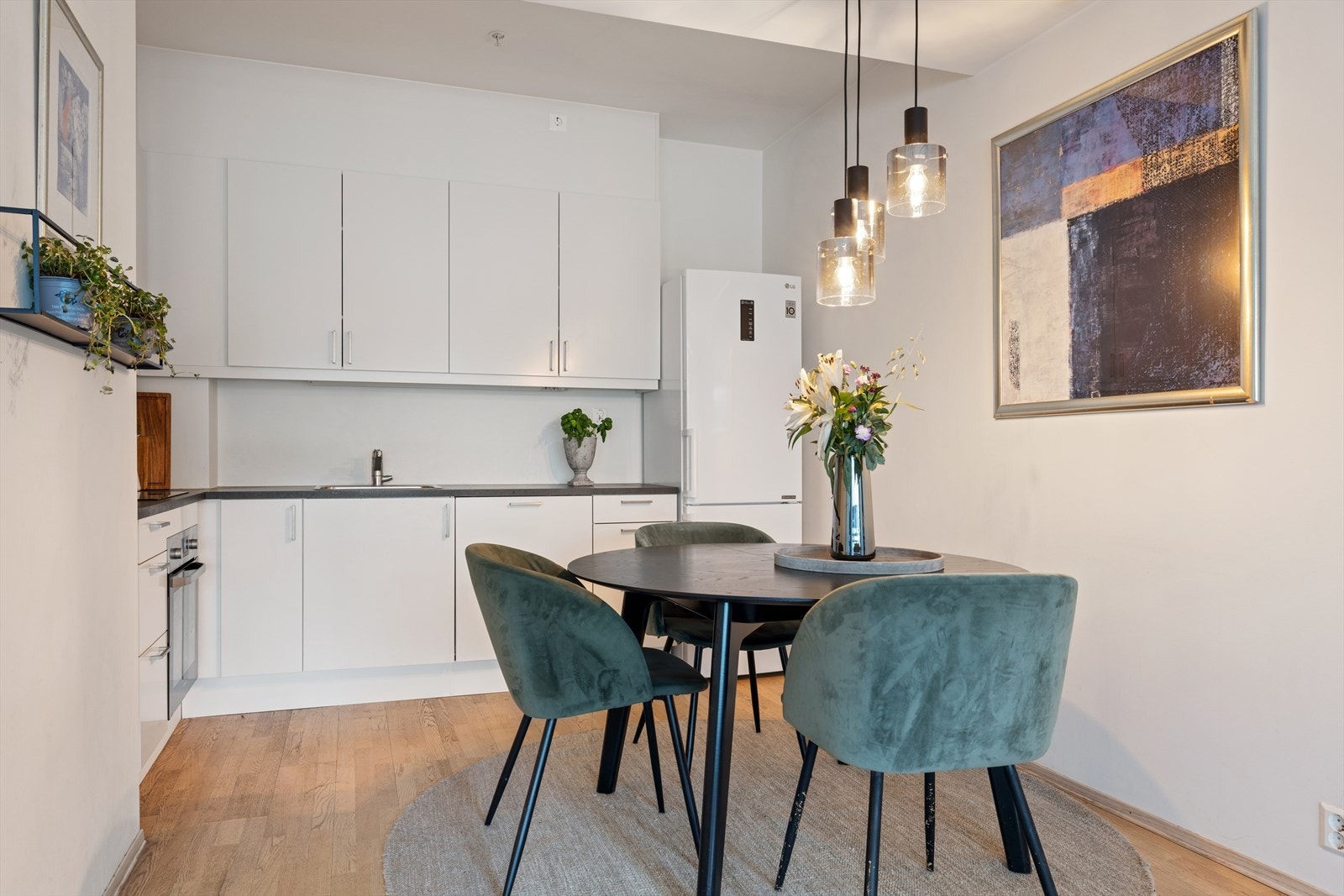 Kjøkkenet er holdt i en tidløs stil med hvite glatte fronter, laminat benkeplate, integrert stekeovn, platetopp og oppvaskmaskin Galleribilde