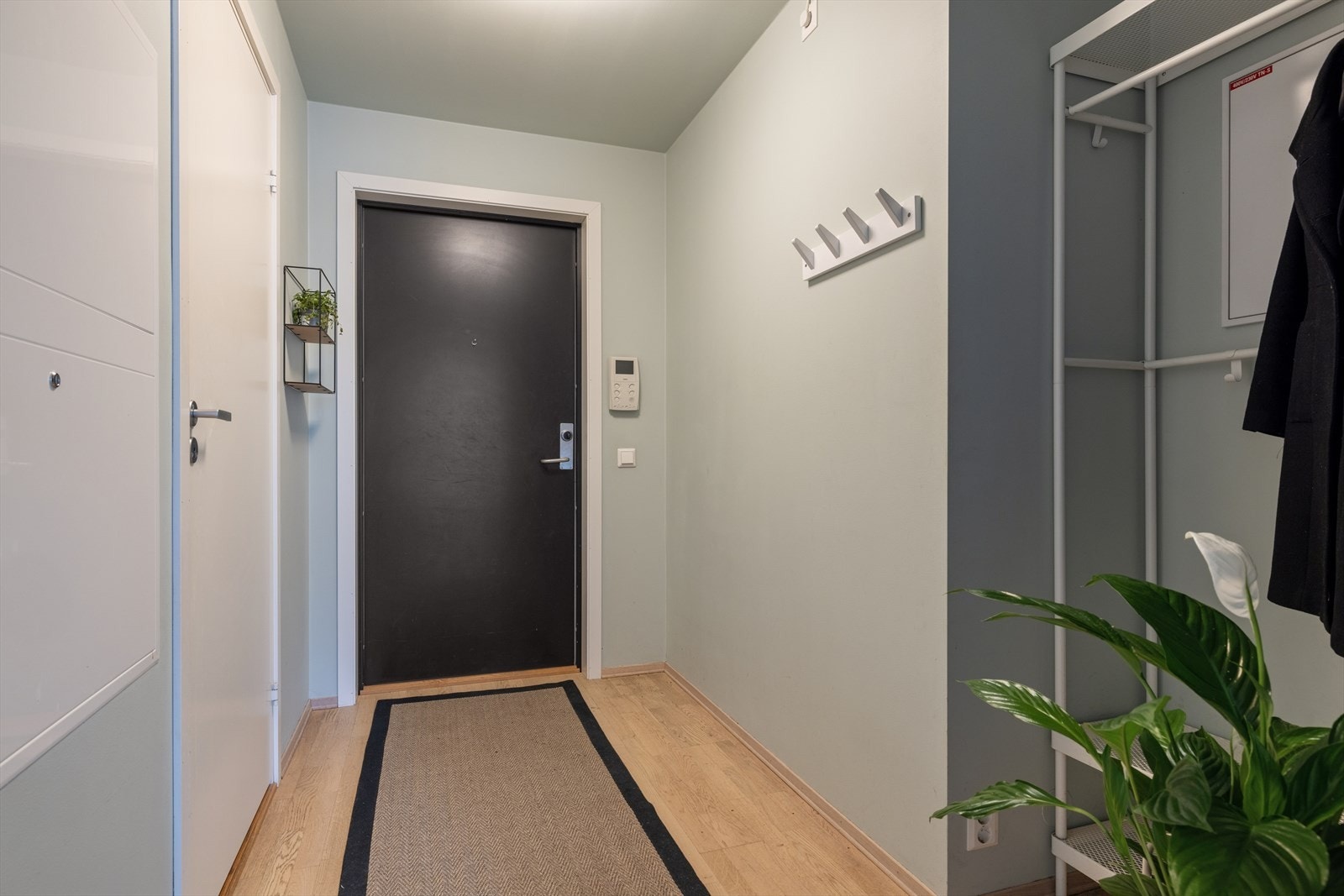 Det er trappefri adkomst via heis opp til leilighetsplan. Entreen er pent innredet med parkett på gulv, knaggrekke og nisje for ytterligere oppbevaringsmuligheter Galleribilde