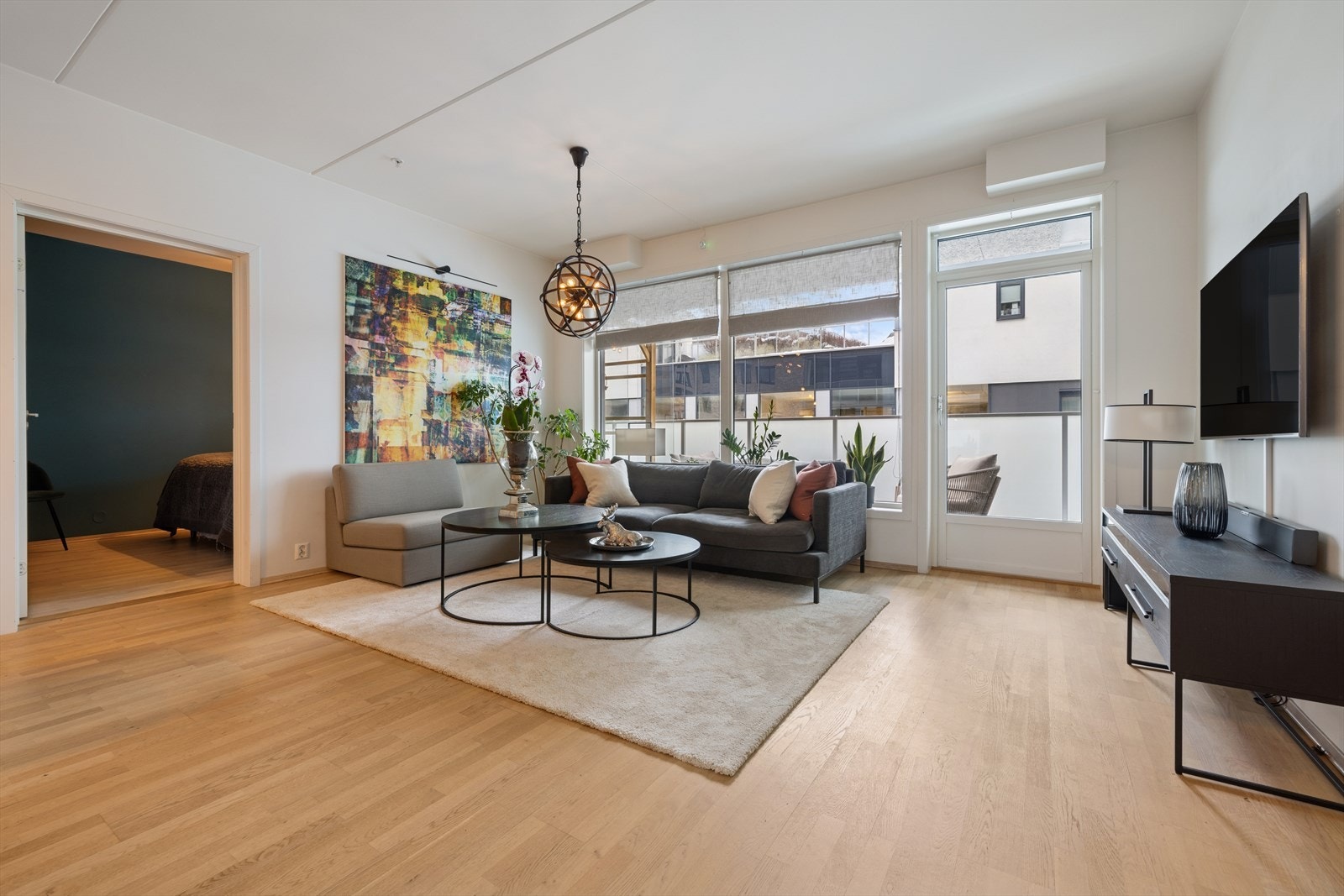 Leilighetens samlingspunkt er den lyse og trivelige stuen med åpen kjøkkenløsning Galleribilde