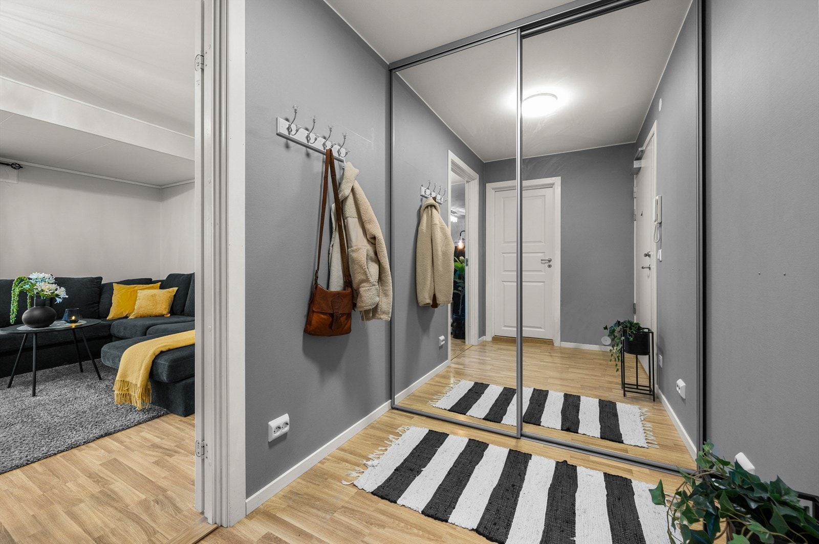 Leiligheten har en romslig entré/gang med stor praktisk skyvedørsgarderobe med speilfronter Galleribilde