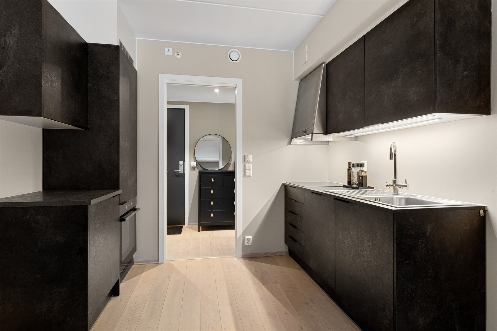 Stilfull kjøkkeninnredning fra Crown Imperial. Innredning med mørke slette fronter og benkeplate i laminat med nedfelt oppvaskkum. Eier har kjøpt til litt ekstra innredning for å få bedre skap og benkplass. Galleribilde