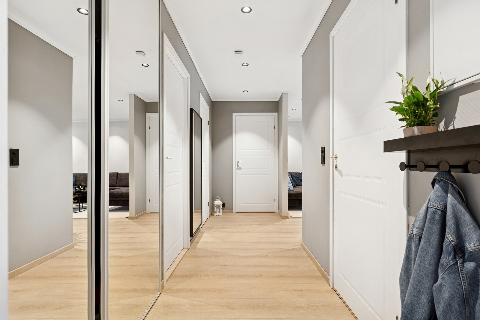 Leiligheten ønsker deg velkommen gjennom en lys og moderne entrè med et helhetlig uttrykk. I entrèen er det god plass til yttertøy og sko, og praktiske løsninger gjør det enkelt å holde det ryddig i hverdagen. Galleribilde